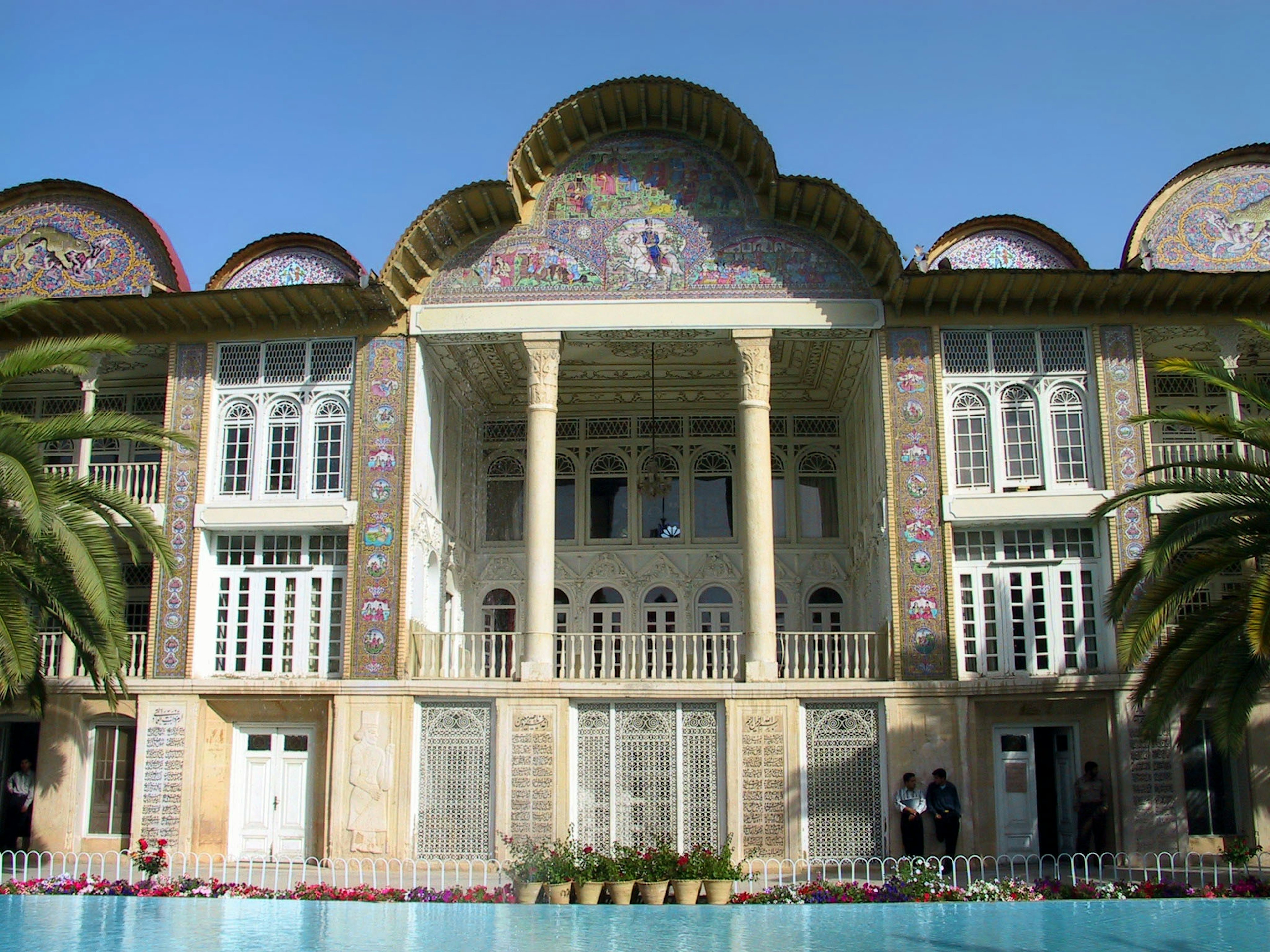 Historic building exterior with ornate decorations surrounded by palm trees