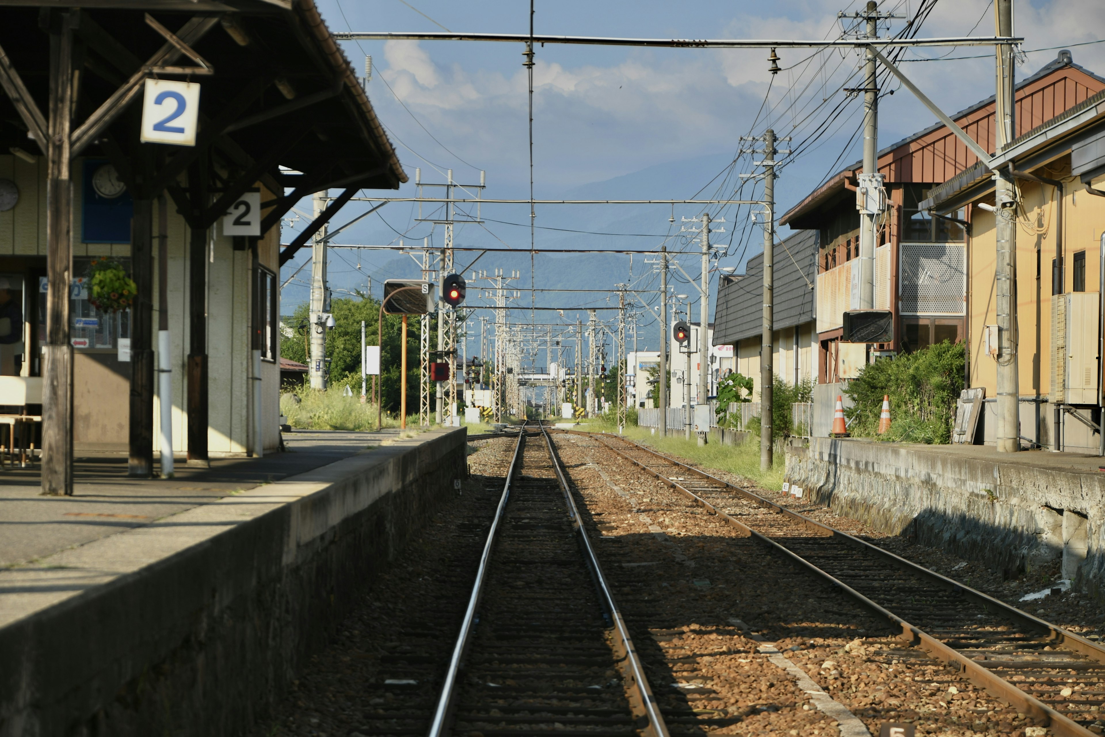 View of a quiet rural train station platform and tracks