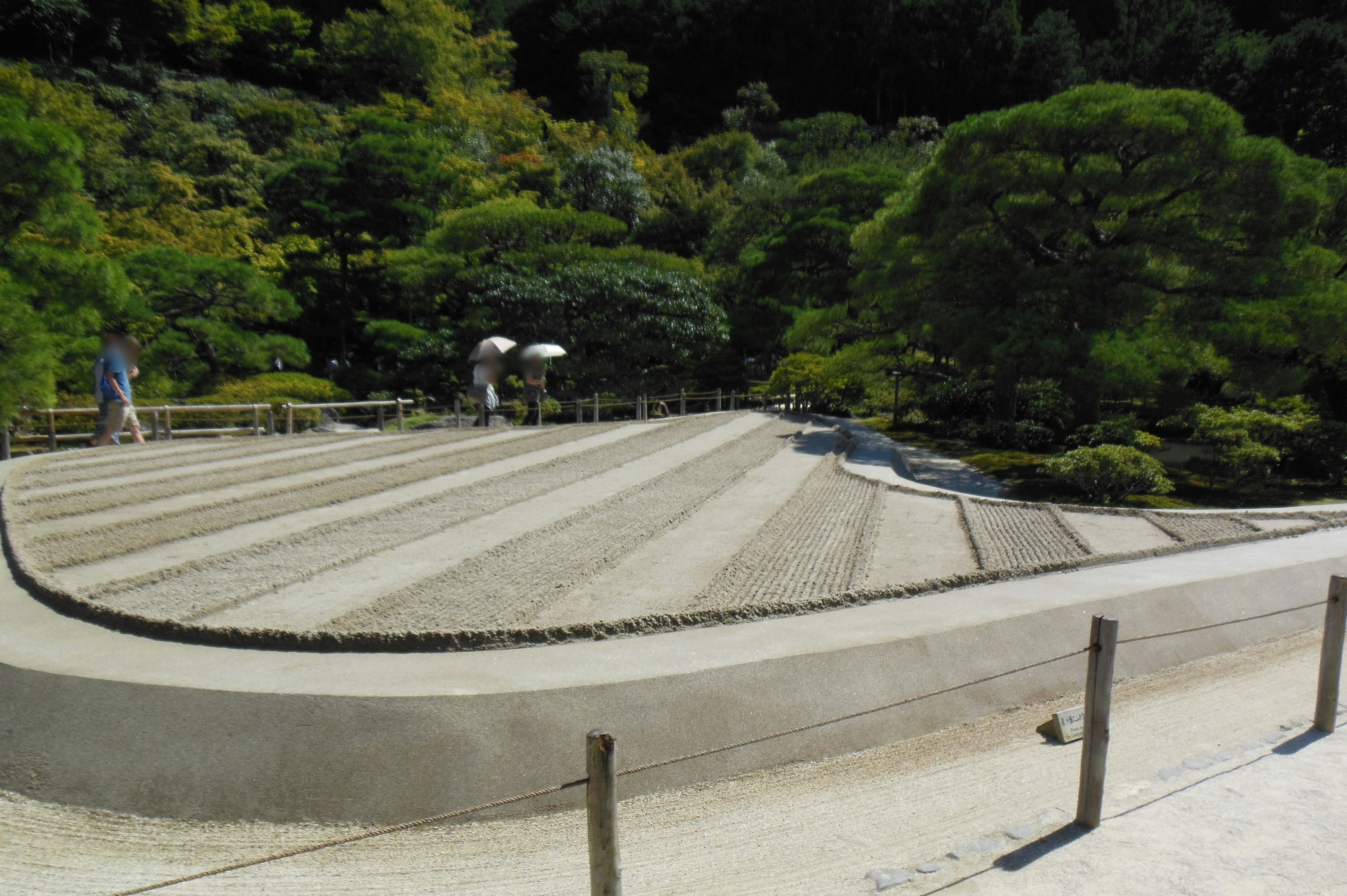 A serene garden scene featuring a raked gravel path and lush greenery