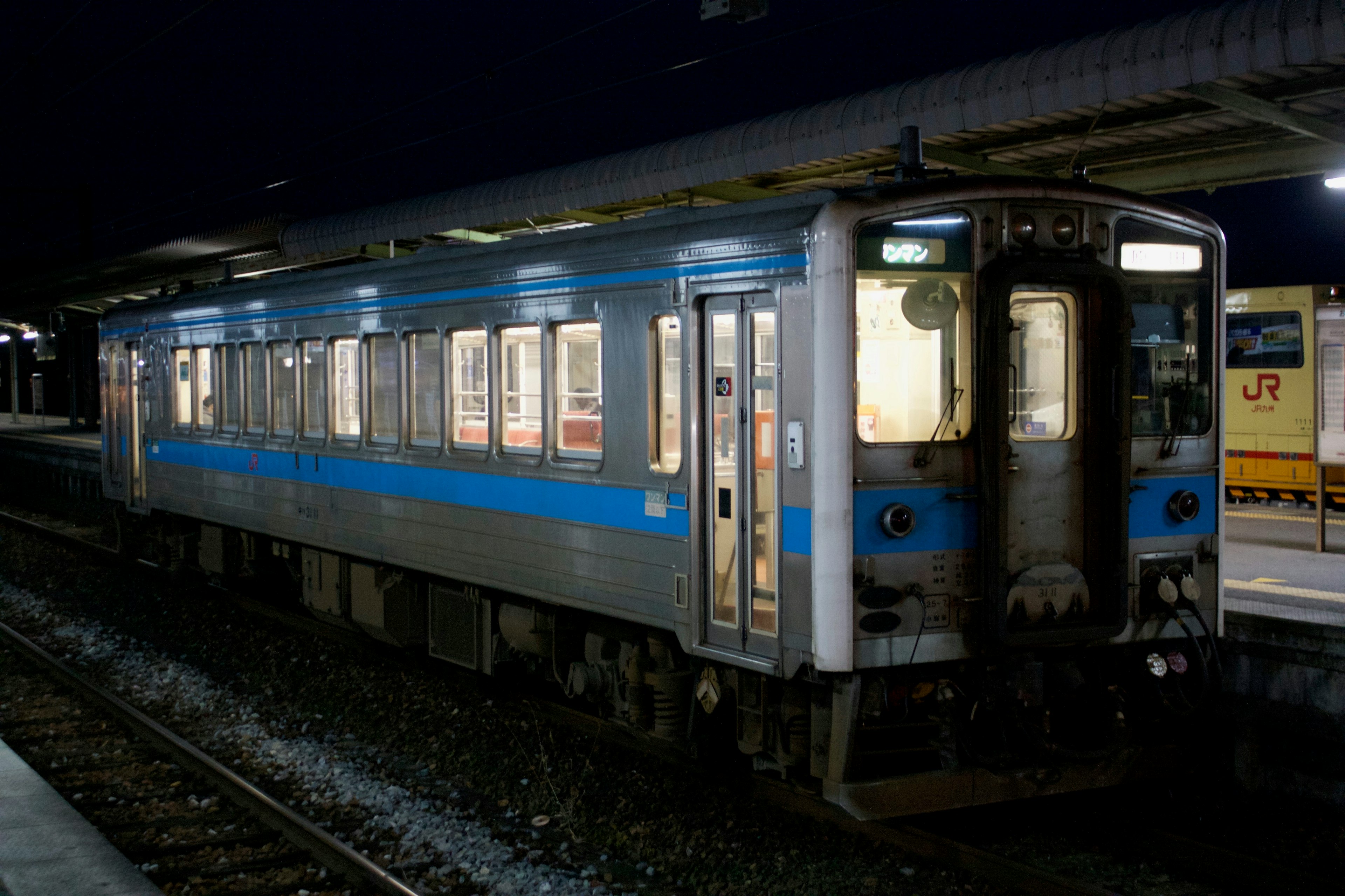 รถไฟสีน้ำเงินจอดที่สถานีในเวลากลางคืน