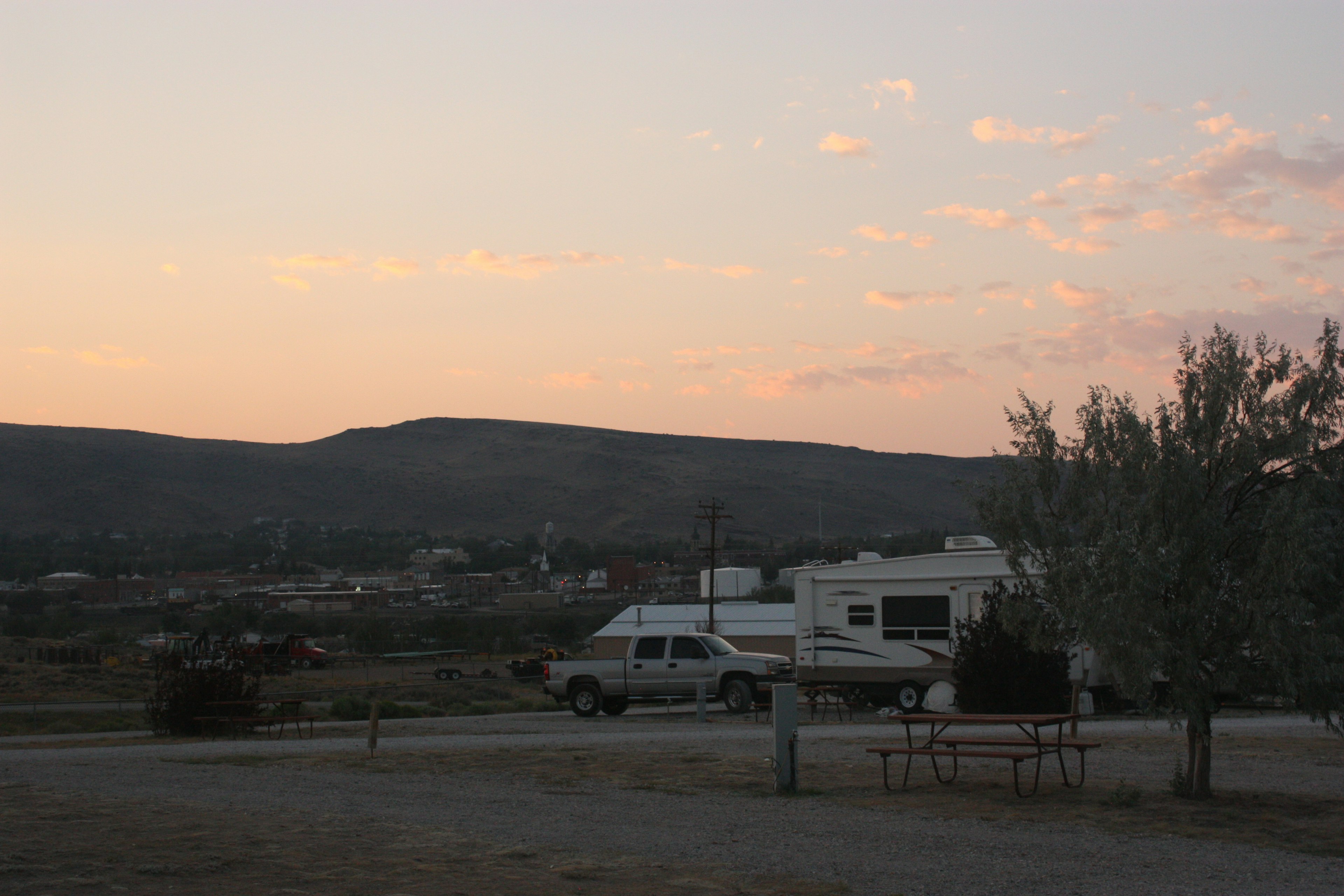 A camper parked at sunset with mountains in the background