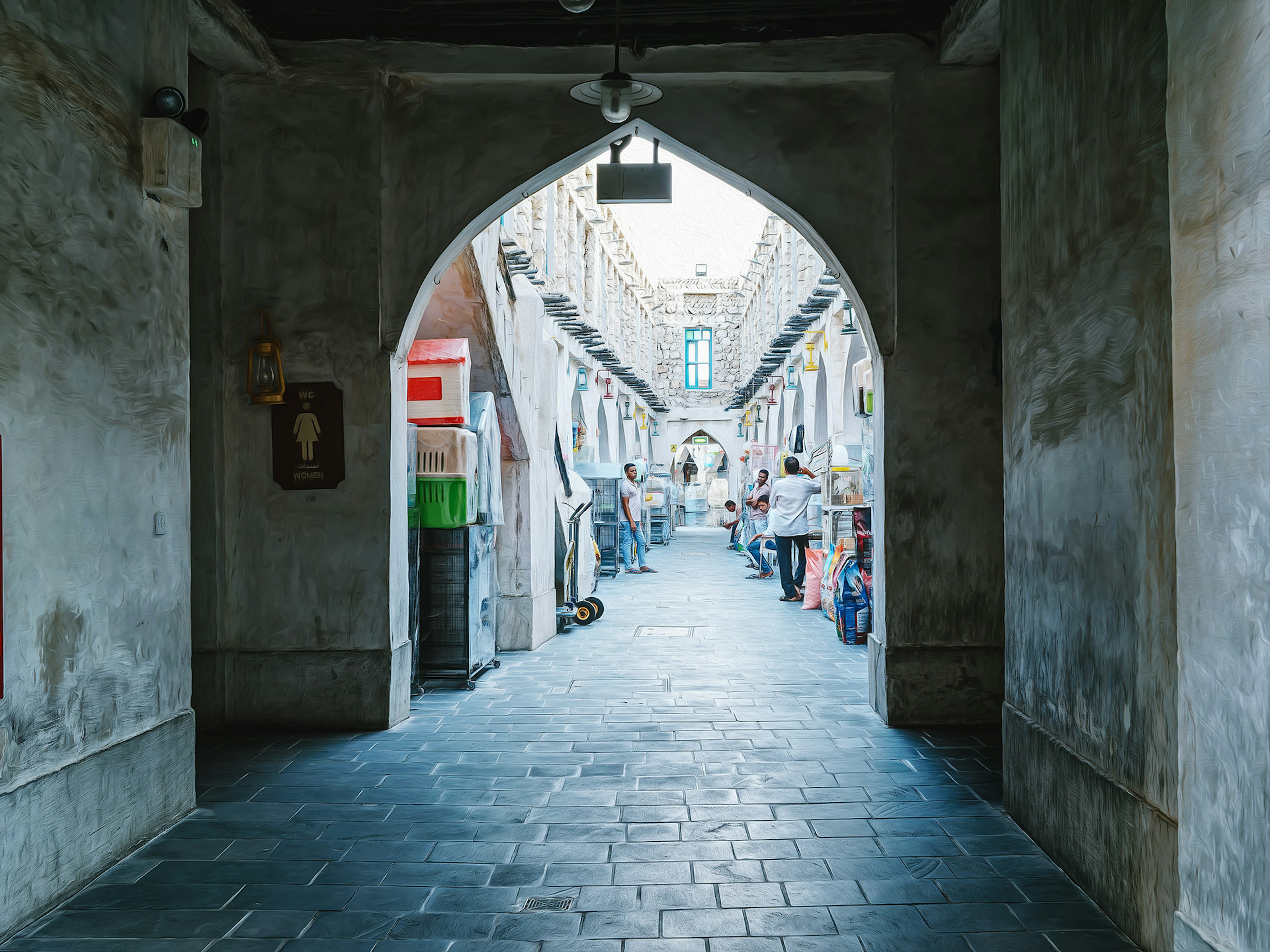 拱门通向狭窄街道，街道上有行人和商店，位于一座古老建筑内