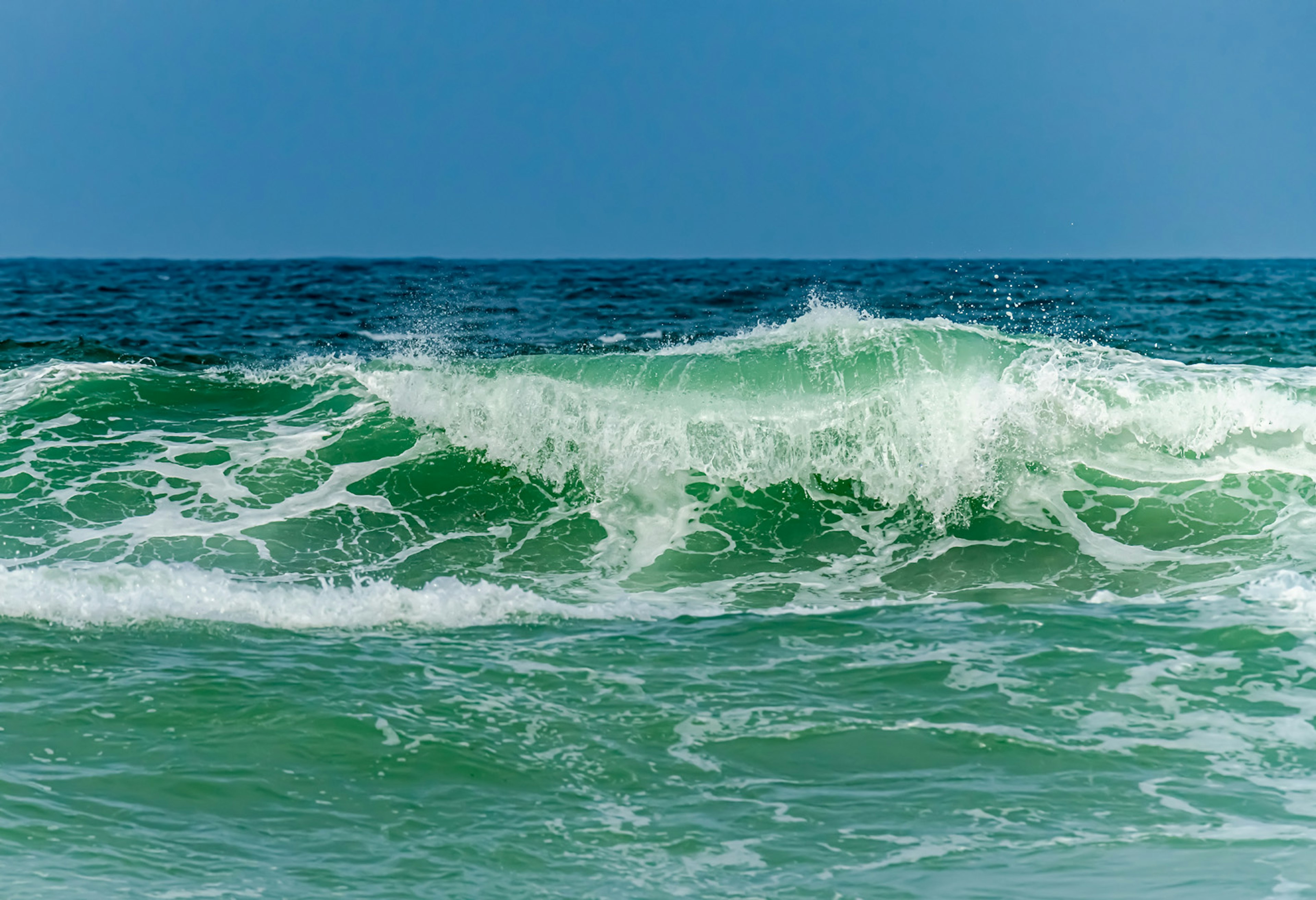 Una vista panoramica di un oceano blu con onde bianche schiumose