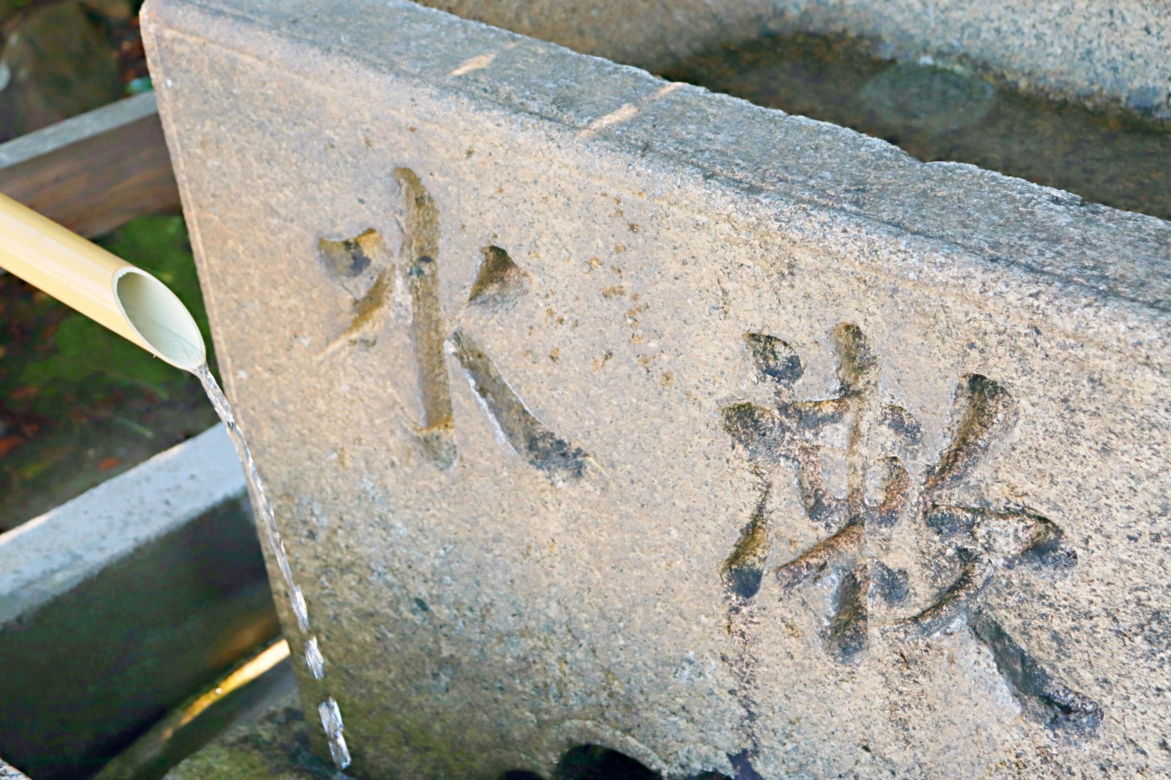 Bañera de piedra tallada con los kanjis para agua y gratitud