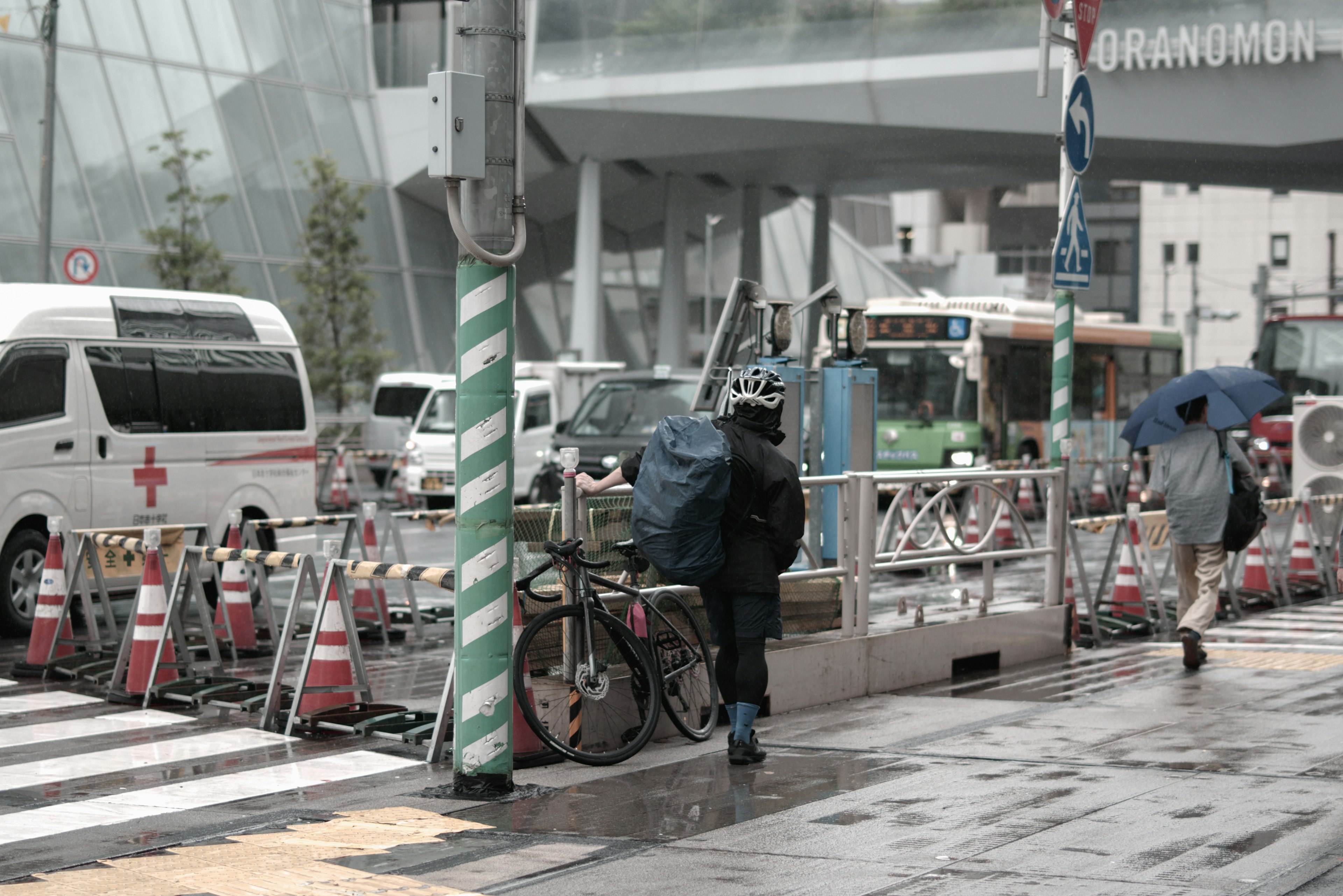 Urban scene with people walking in the rain and a bicycle