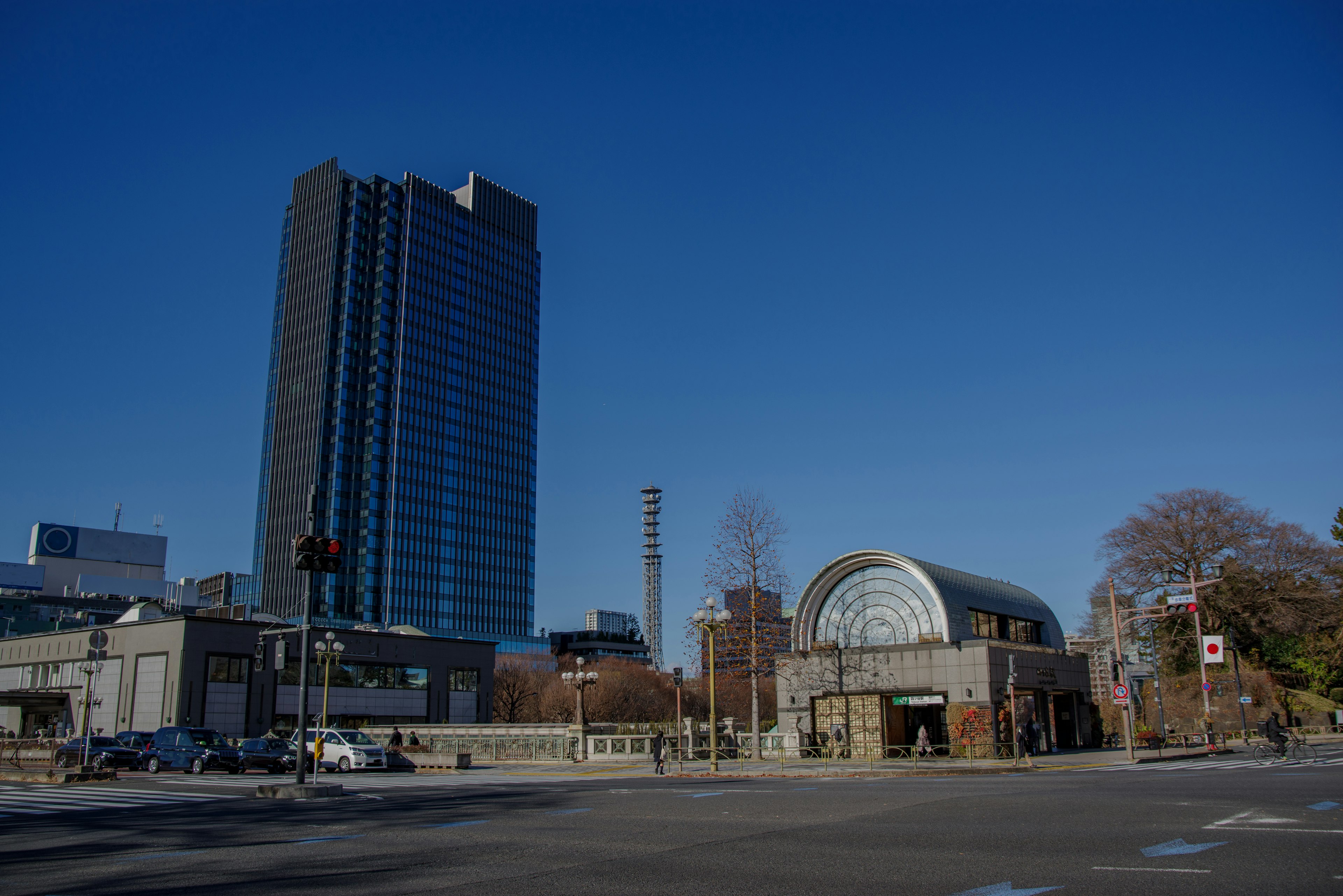 Un edificio alto e una struttura a forma di arco sotto un cielo blu chiaro