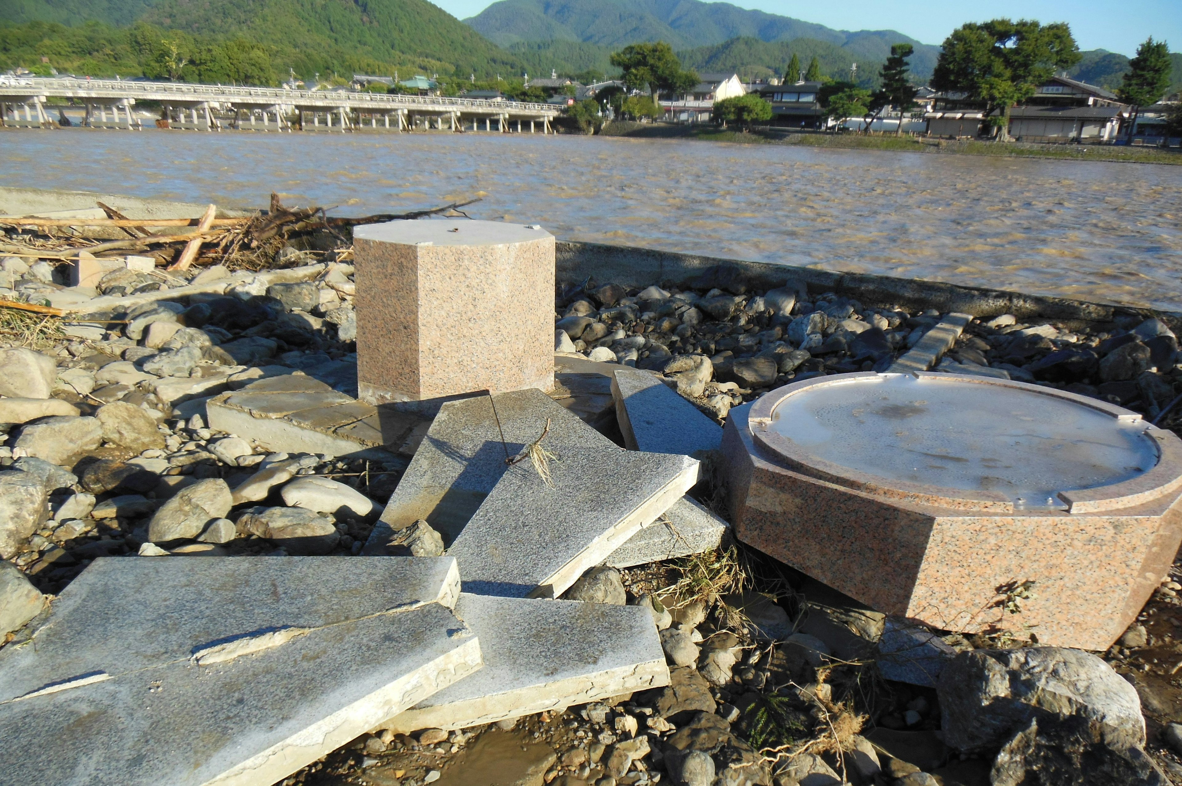 Scattered stone and concrete debris along the riverbank