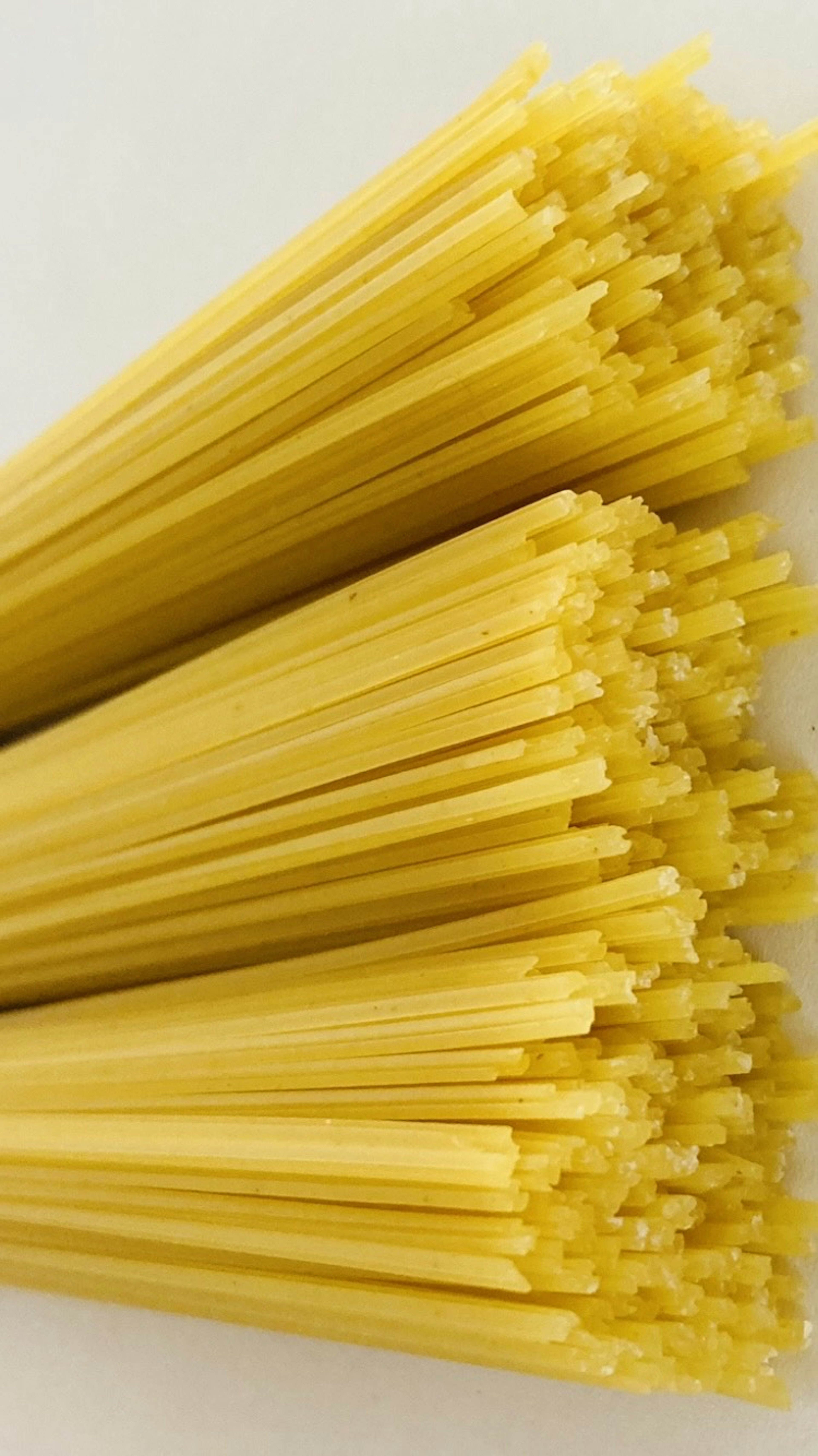 Des paquets de spaghetti jaunes disposés de manière ordonnée