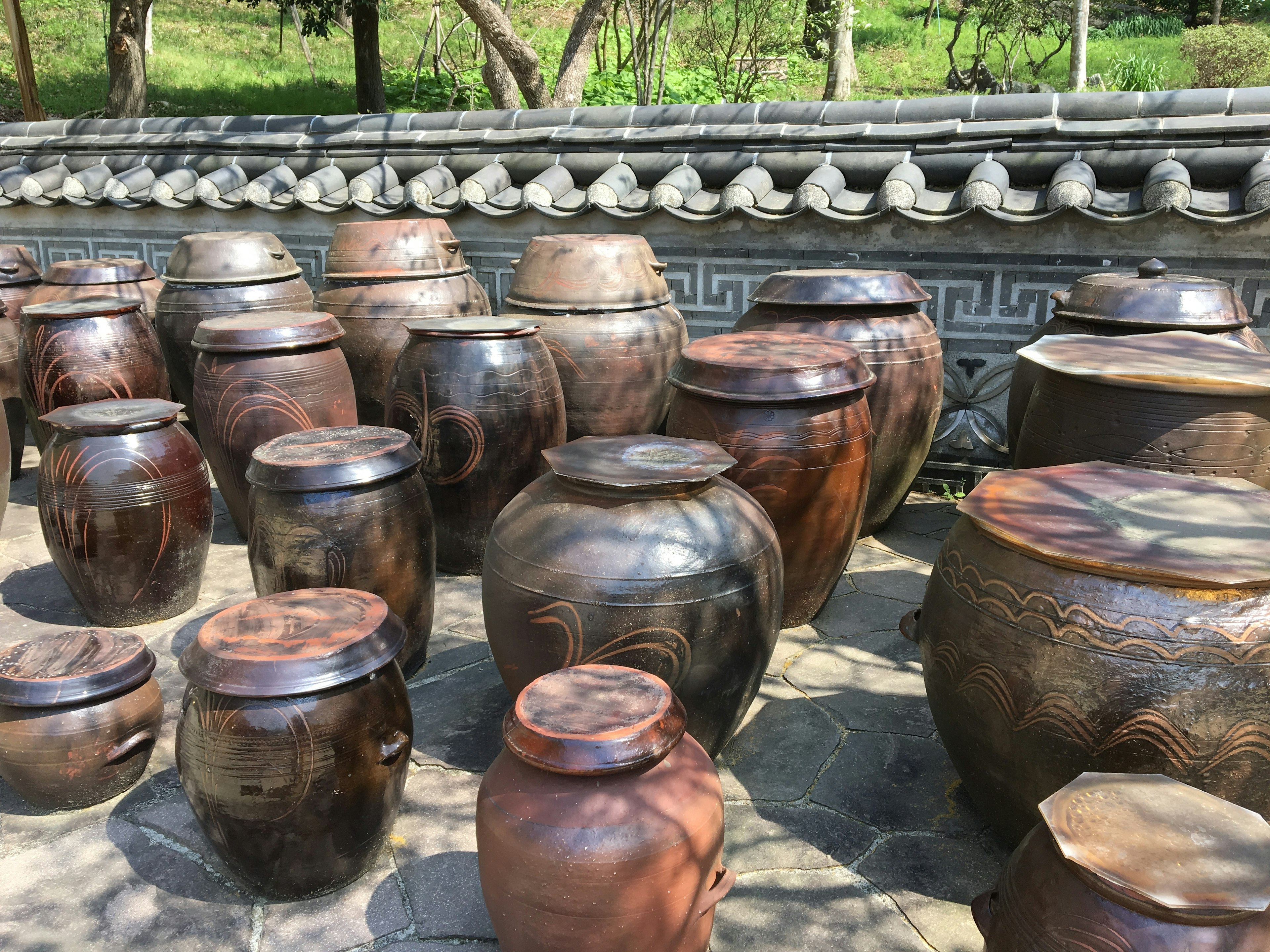 A collection of traditional pottery jars arranged in an outdoor setting