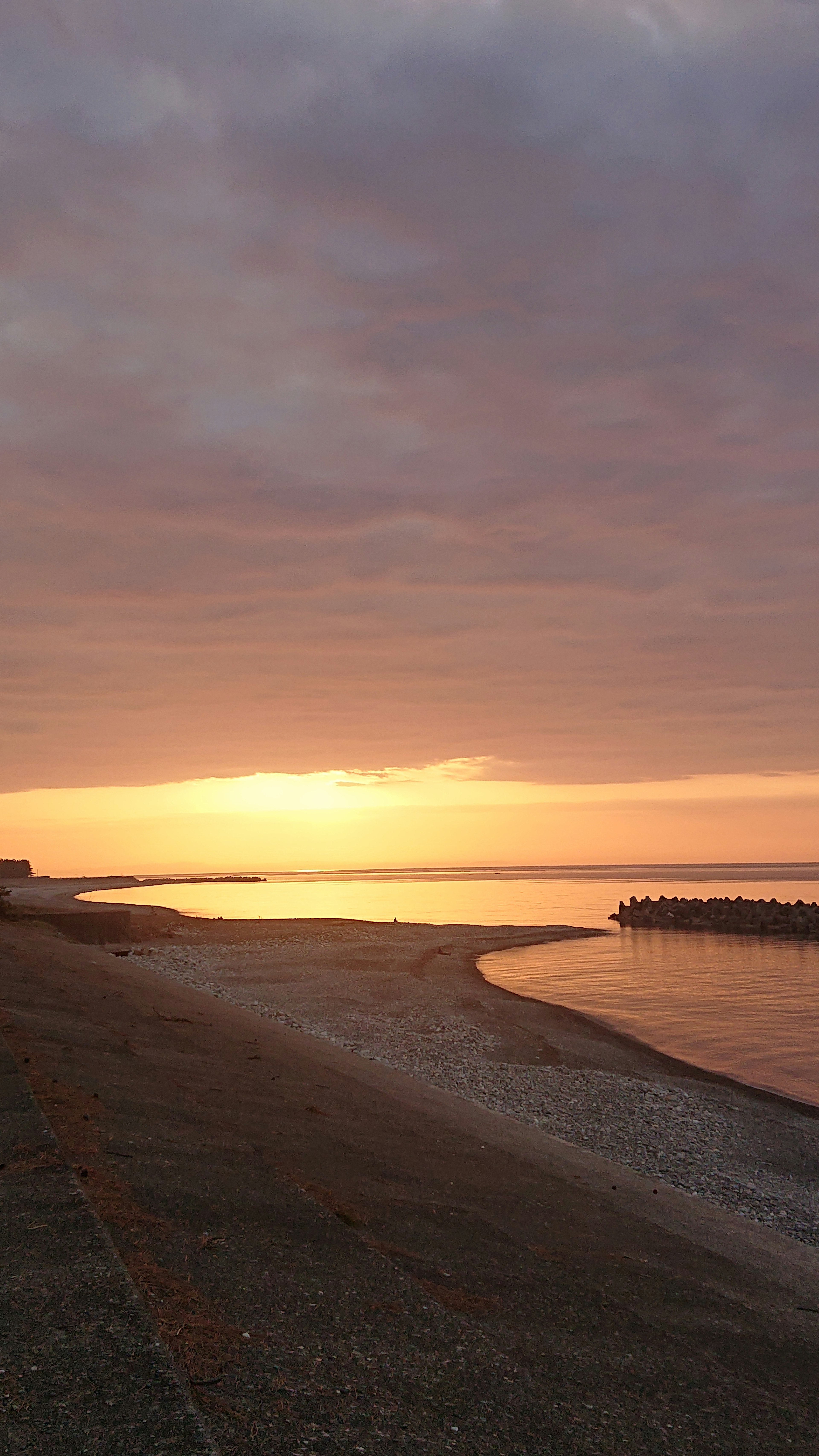 Ruhiger Strand Sonnenuntergang mit sanften Farben und ruhigem Wasser