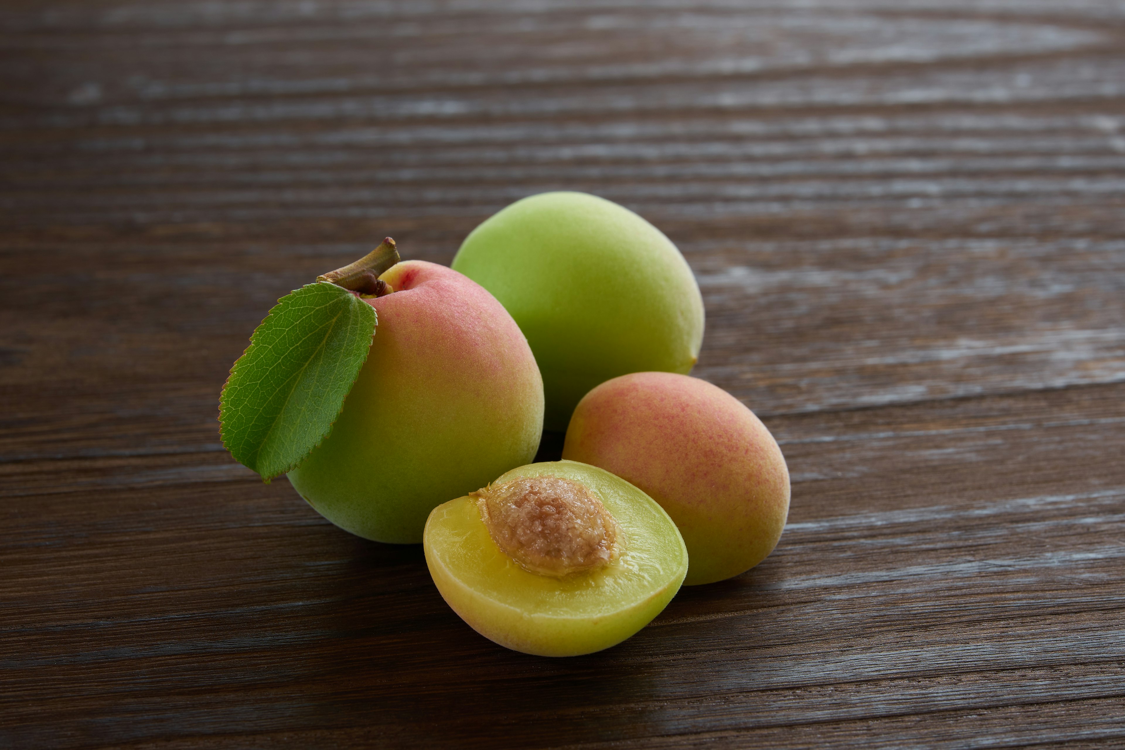 Grüne Äpfel und ein geschnittener Apfel auf einem Holztisch