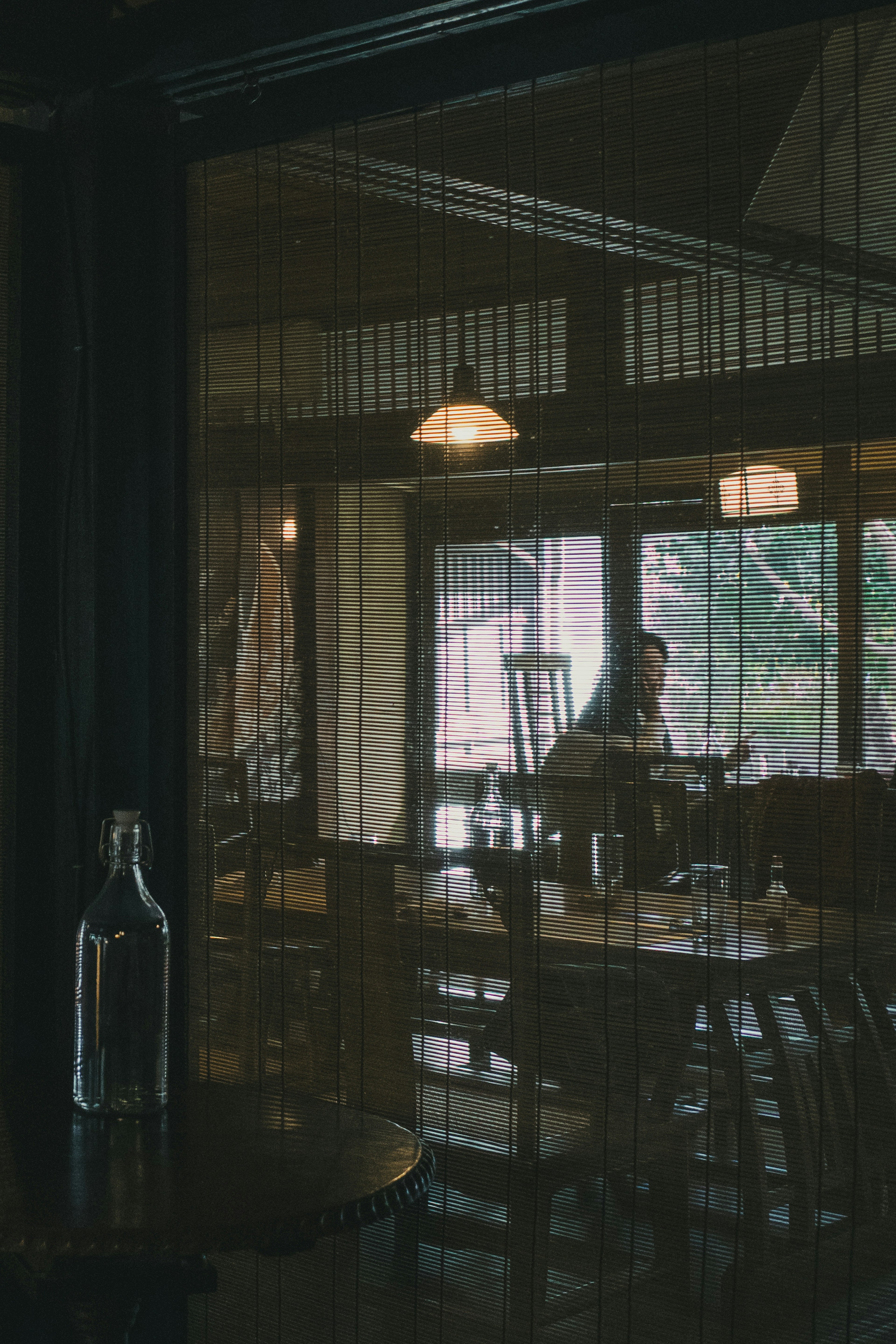 Interior of a cozy café with wooden tables and chairs illuminated by natural light through the windows