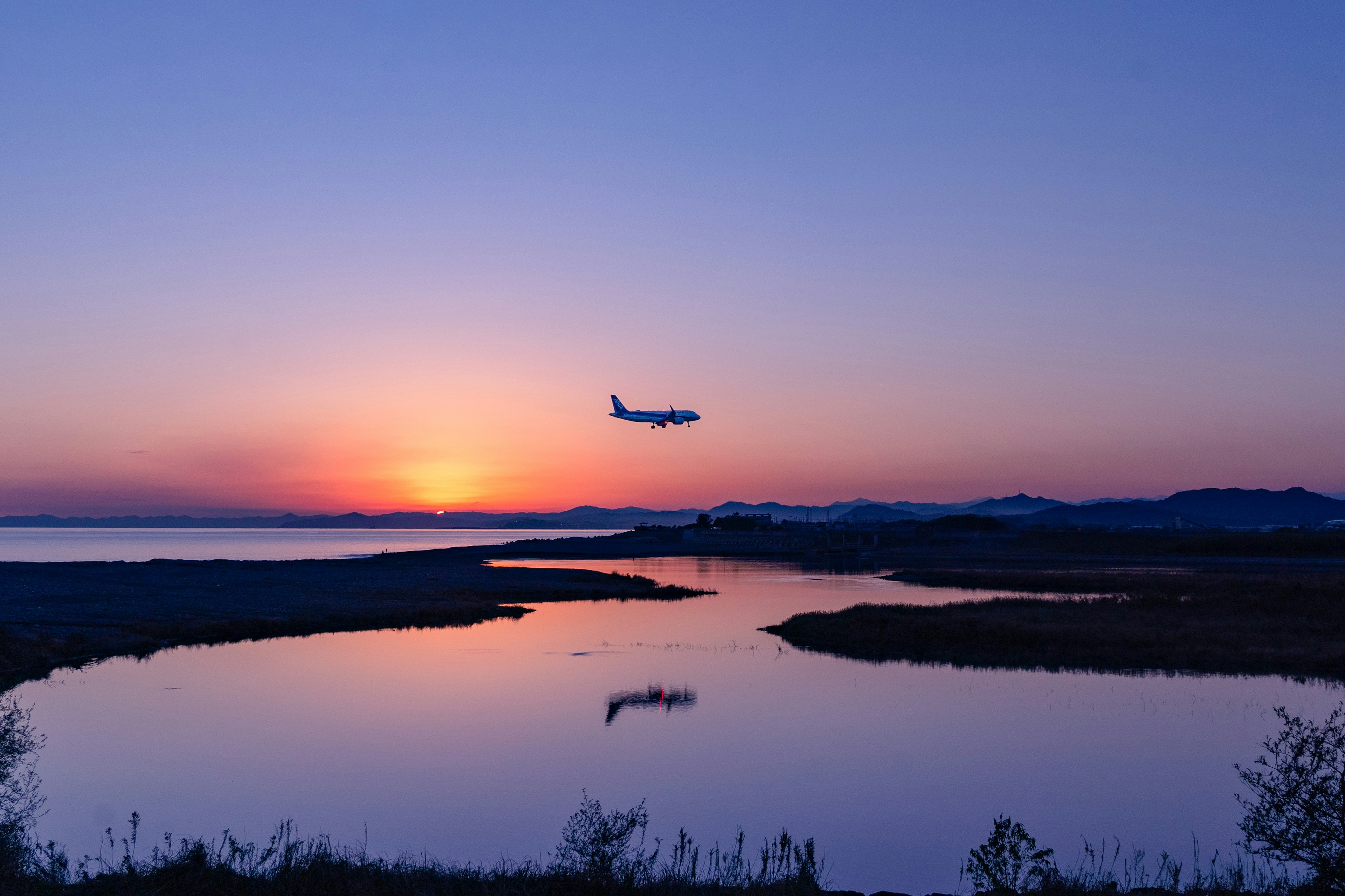 夕焼けの空を背景に飛行機が着陸する美しい風景