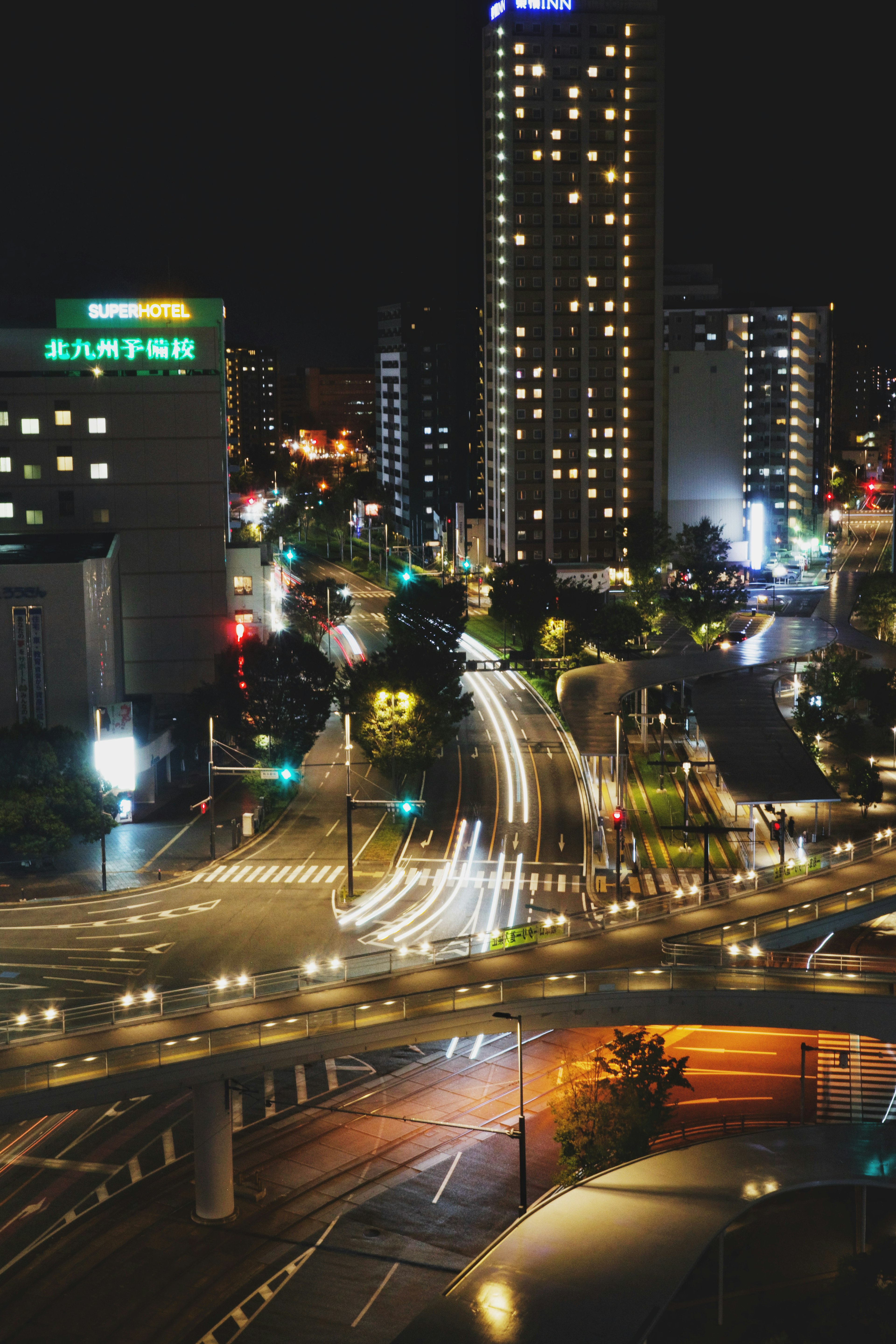 Intersection de la ville la nuit avec des gratte-ciel illuminés et des feux de circulation