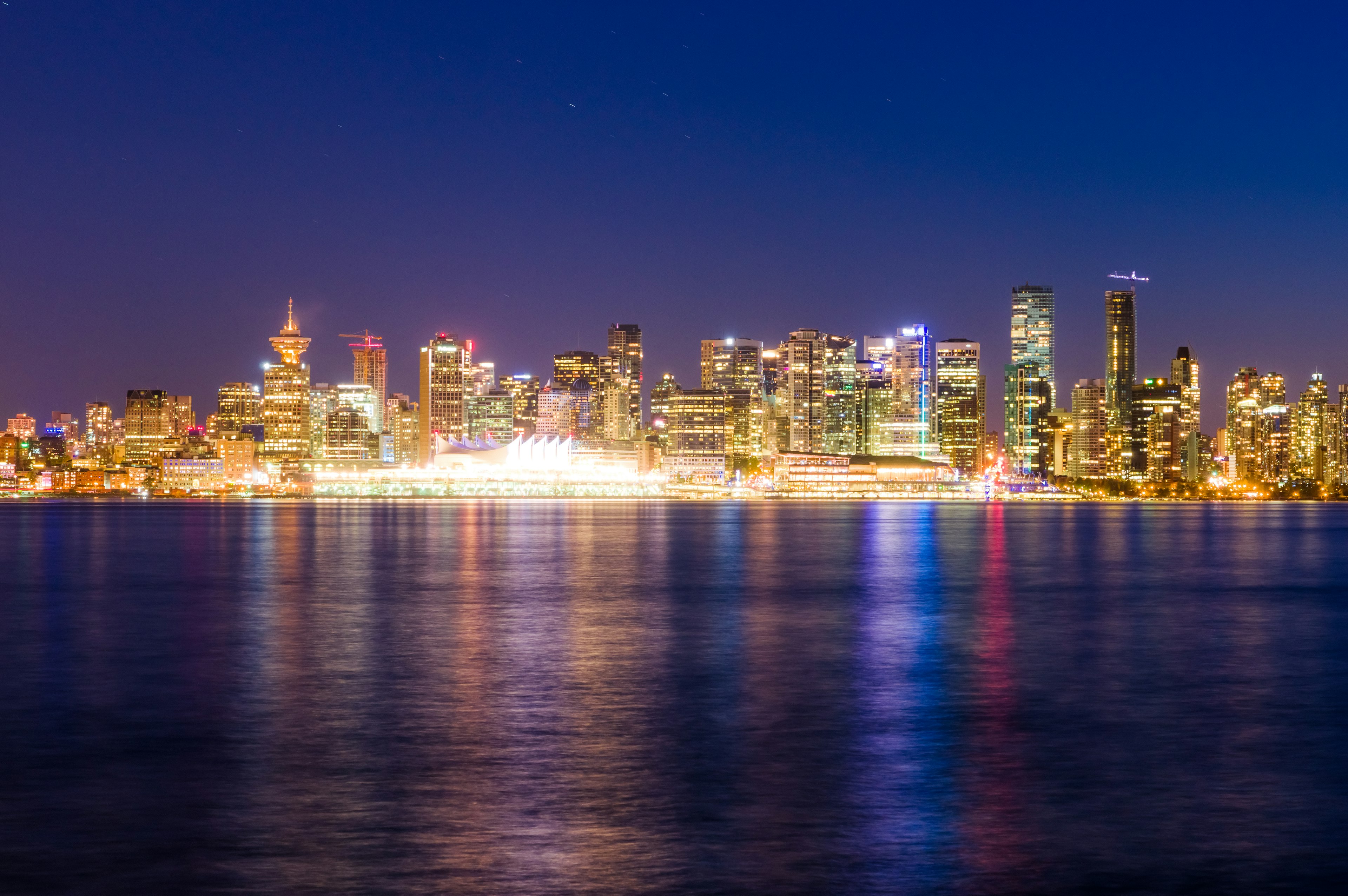 Hermosa vista nocturna del horizonte de Vancouver reflejada en el agua