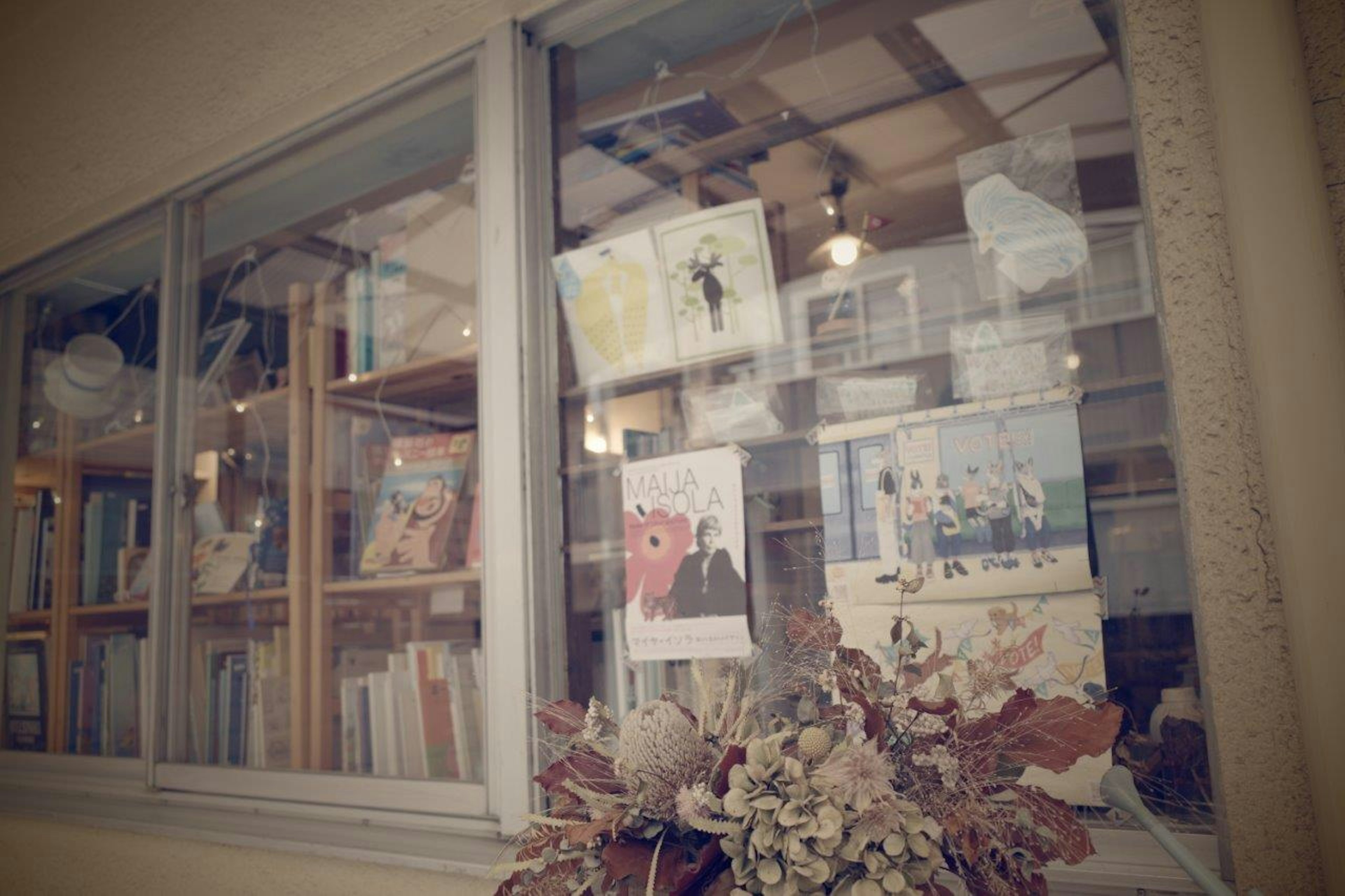 Exterior view of a window with bookshelves and posters