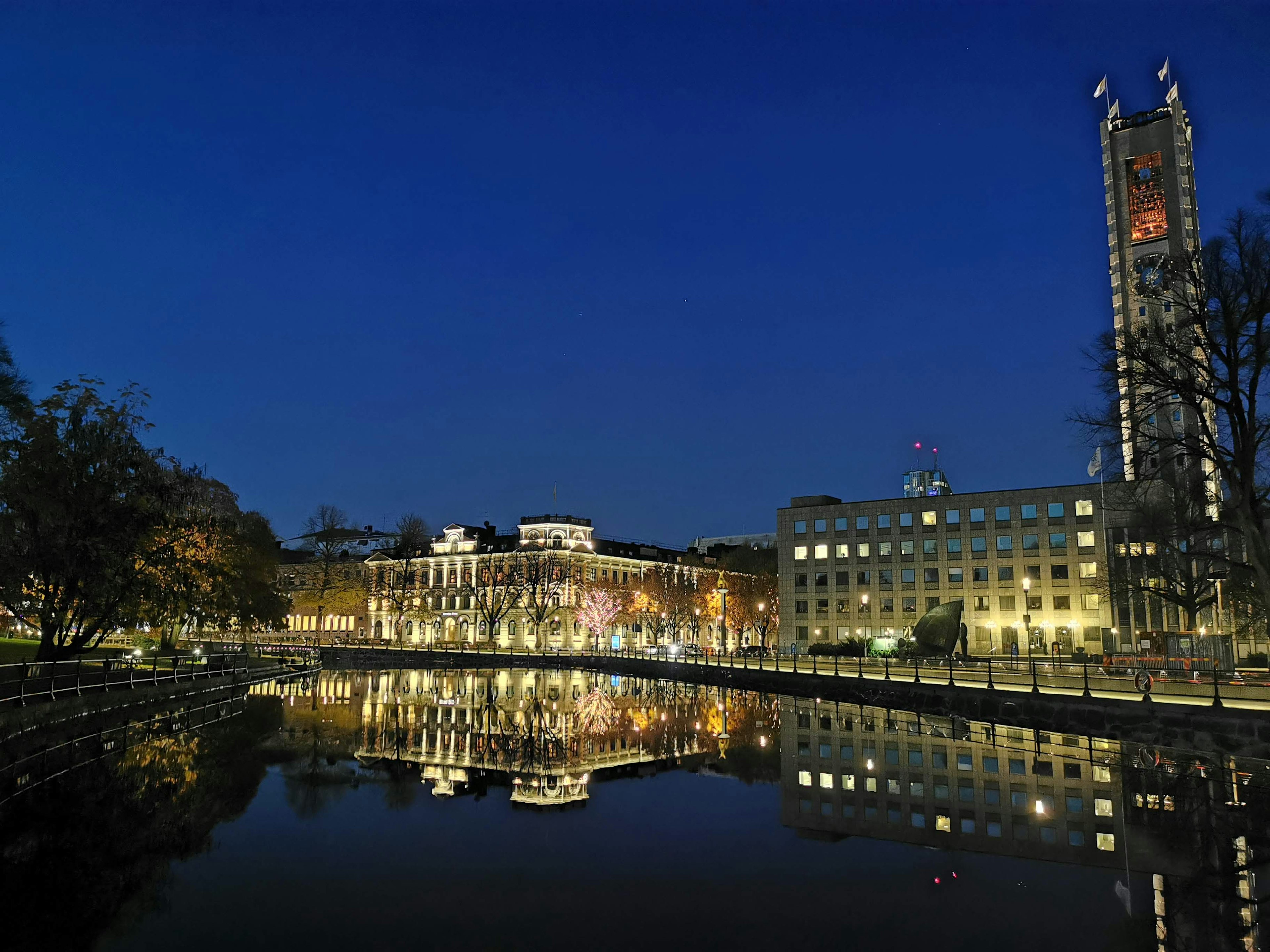 Bâtiments et lampadaires reflétés sur l'eau calme de nuit