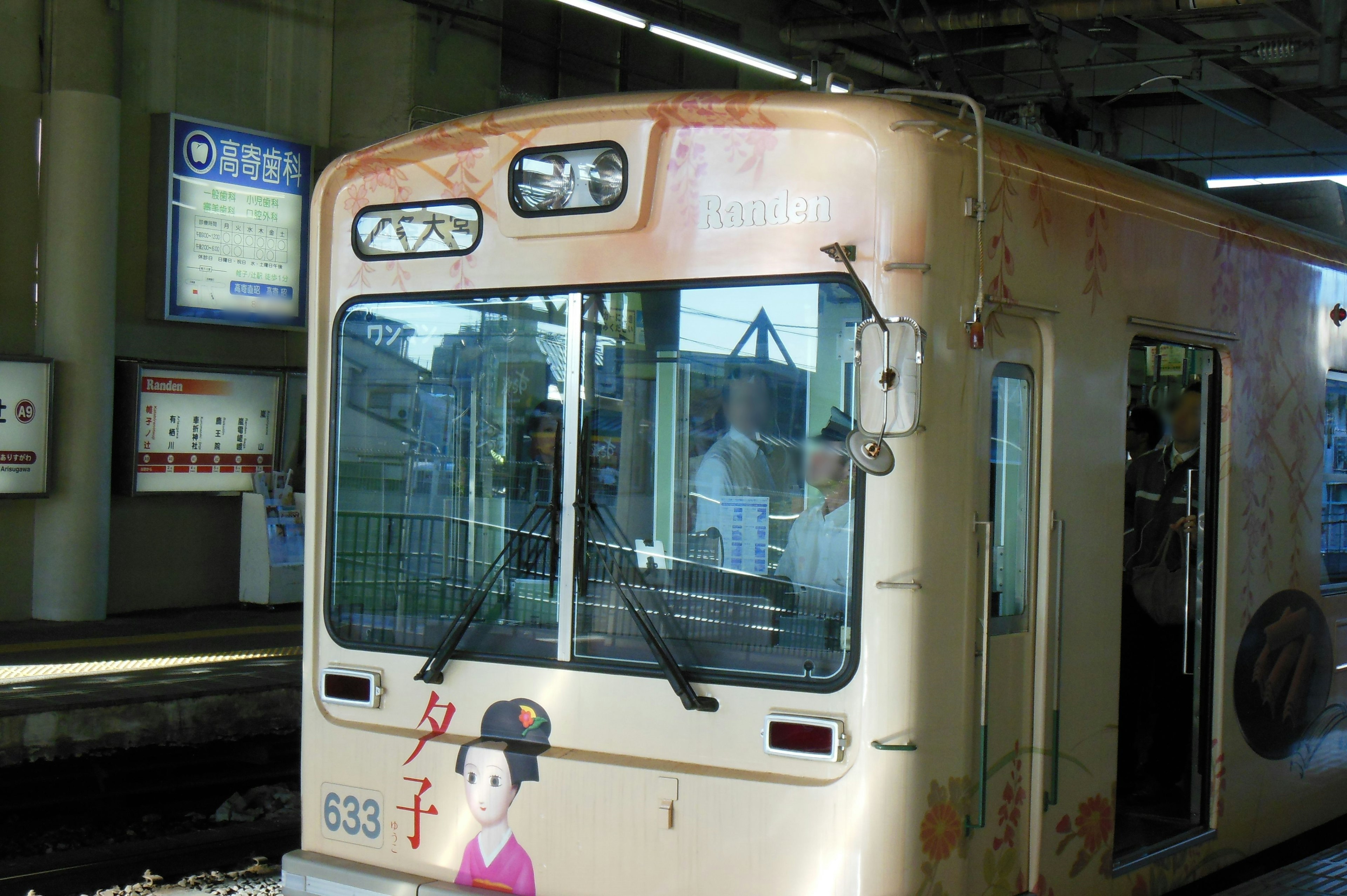 Vista frontale di un treno vintage in stazione con passeggeri visibili attraverso i finestrini