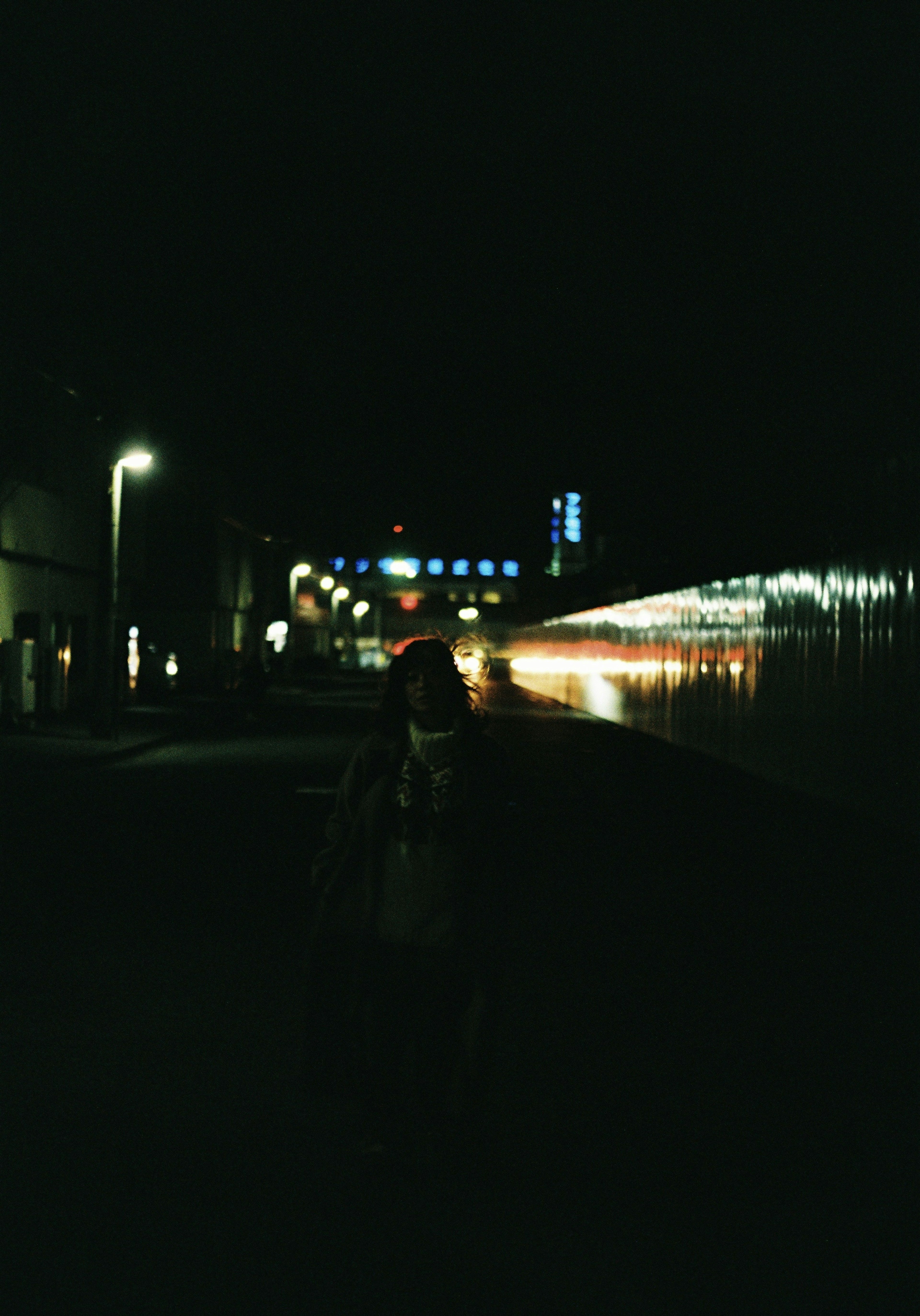 Scène nocturne d'une gare avec un éclairage ambiant et une silhouette humaine