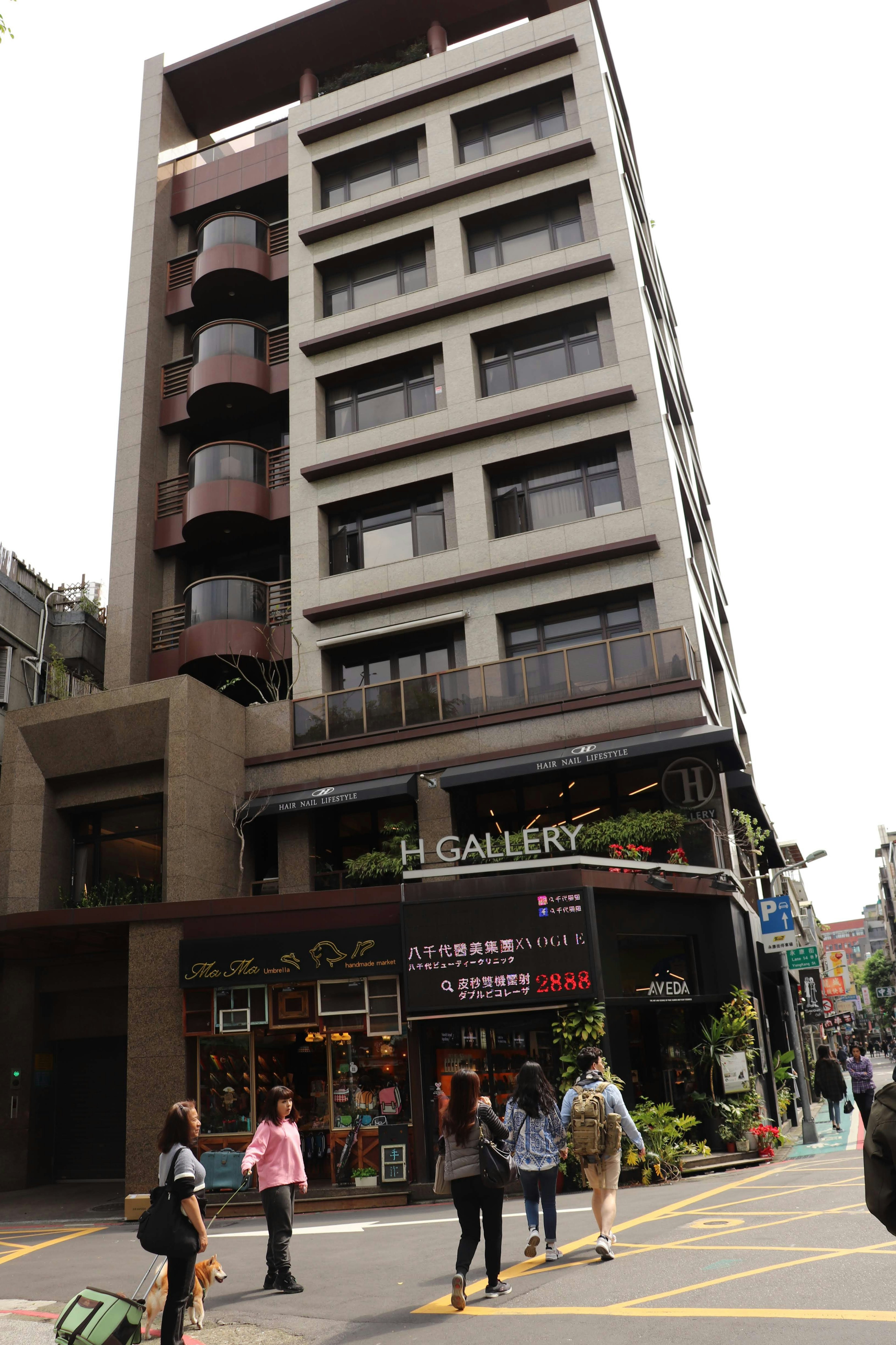 Urban scene featuring a tall building and pedestrians