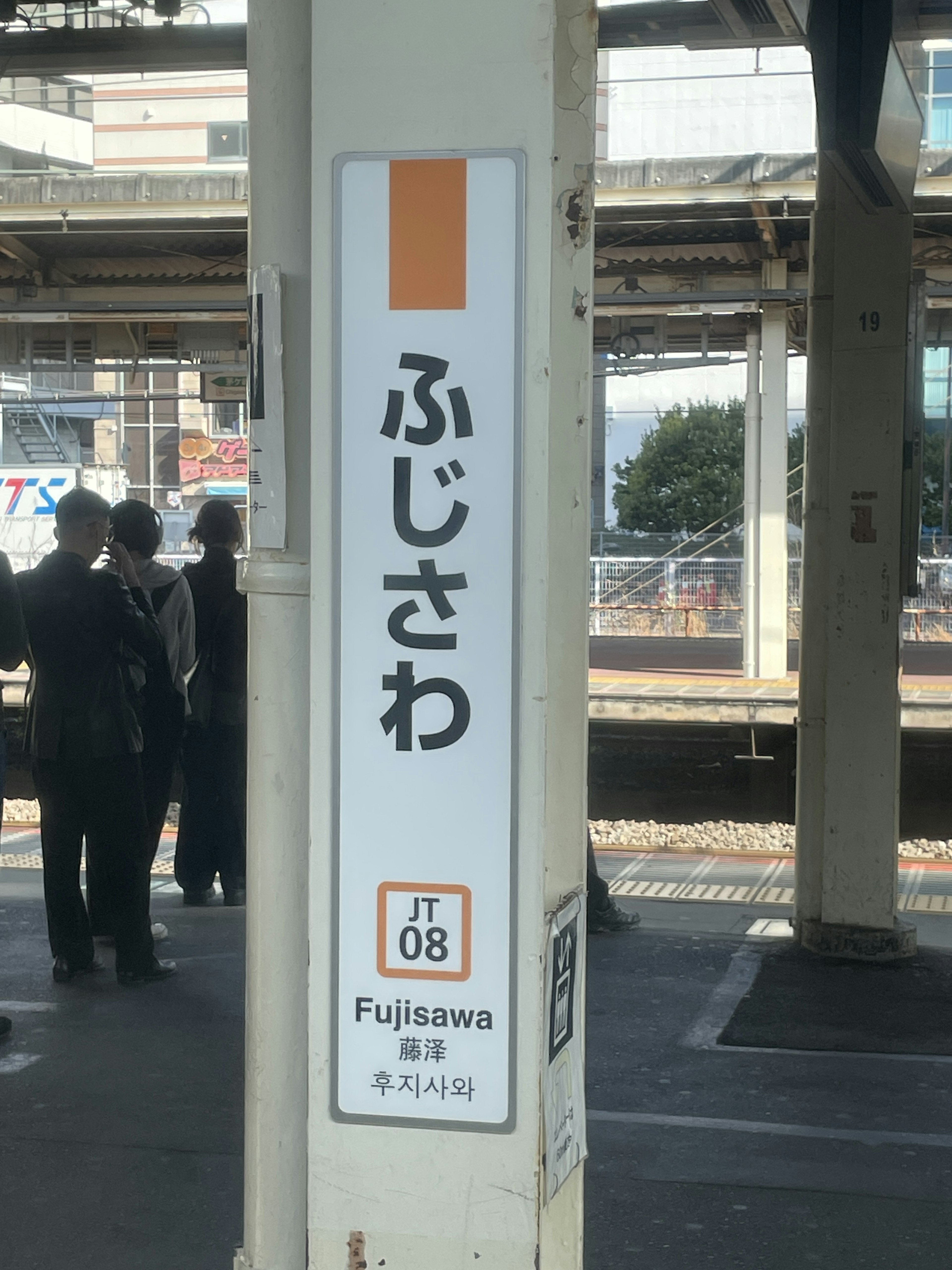 藤沢駅の看板と乗客がいる風景