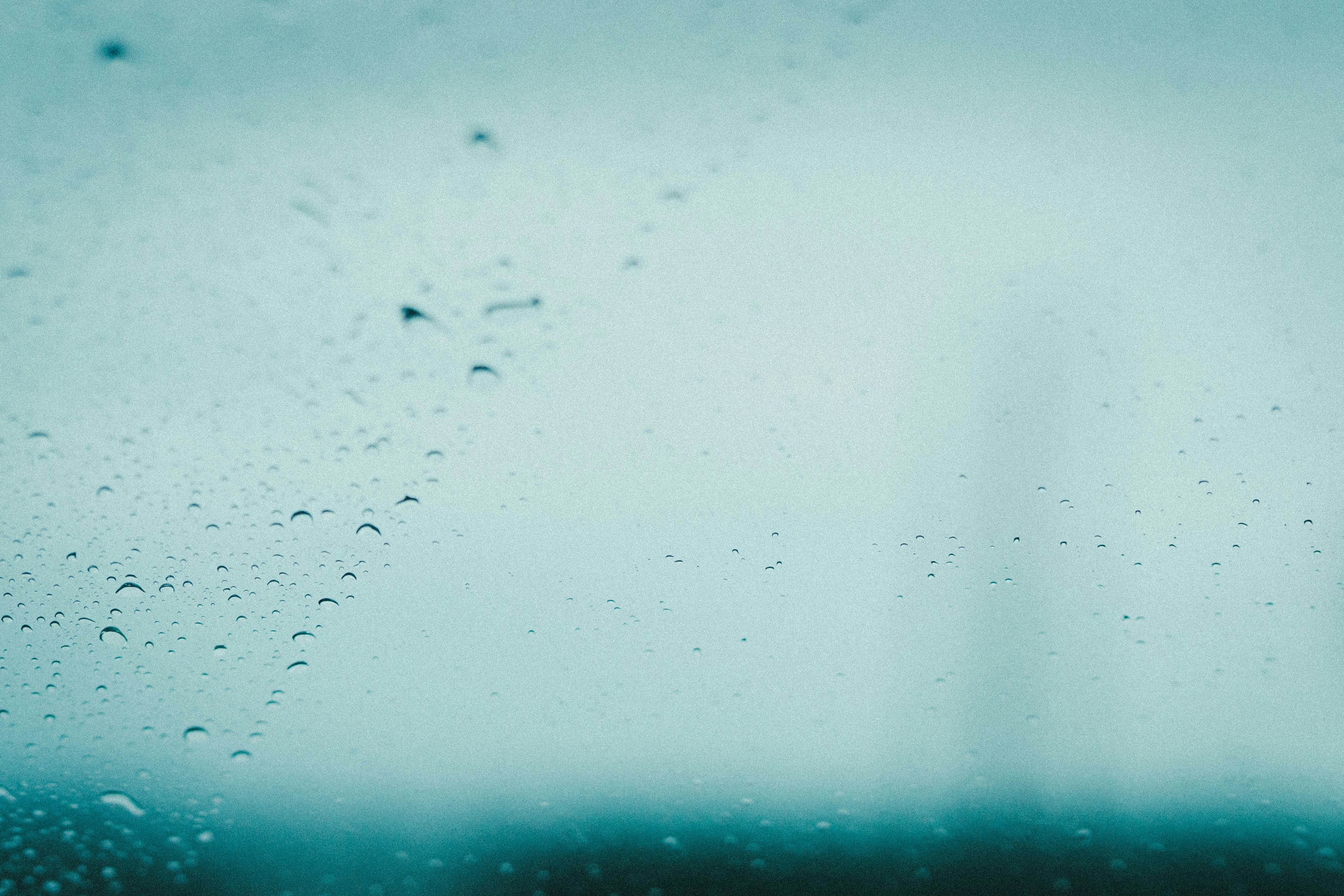 Close-up of raindrops on a window with a blurred background