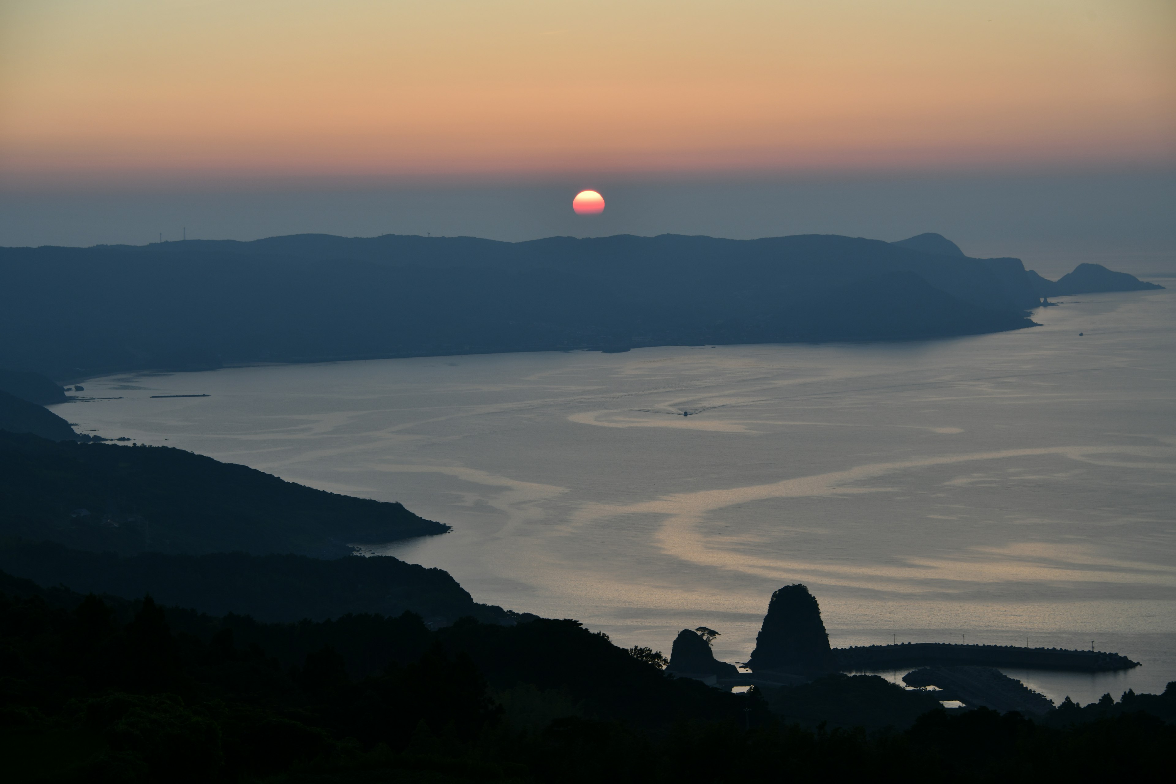 海岸線に沈む夕日と静かな海の風景