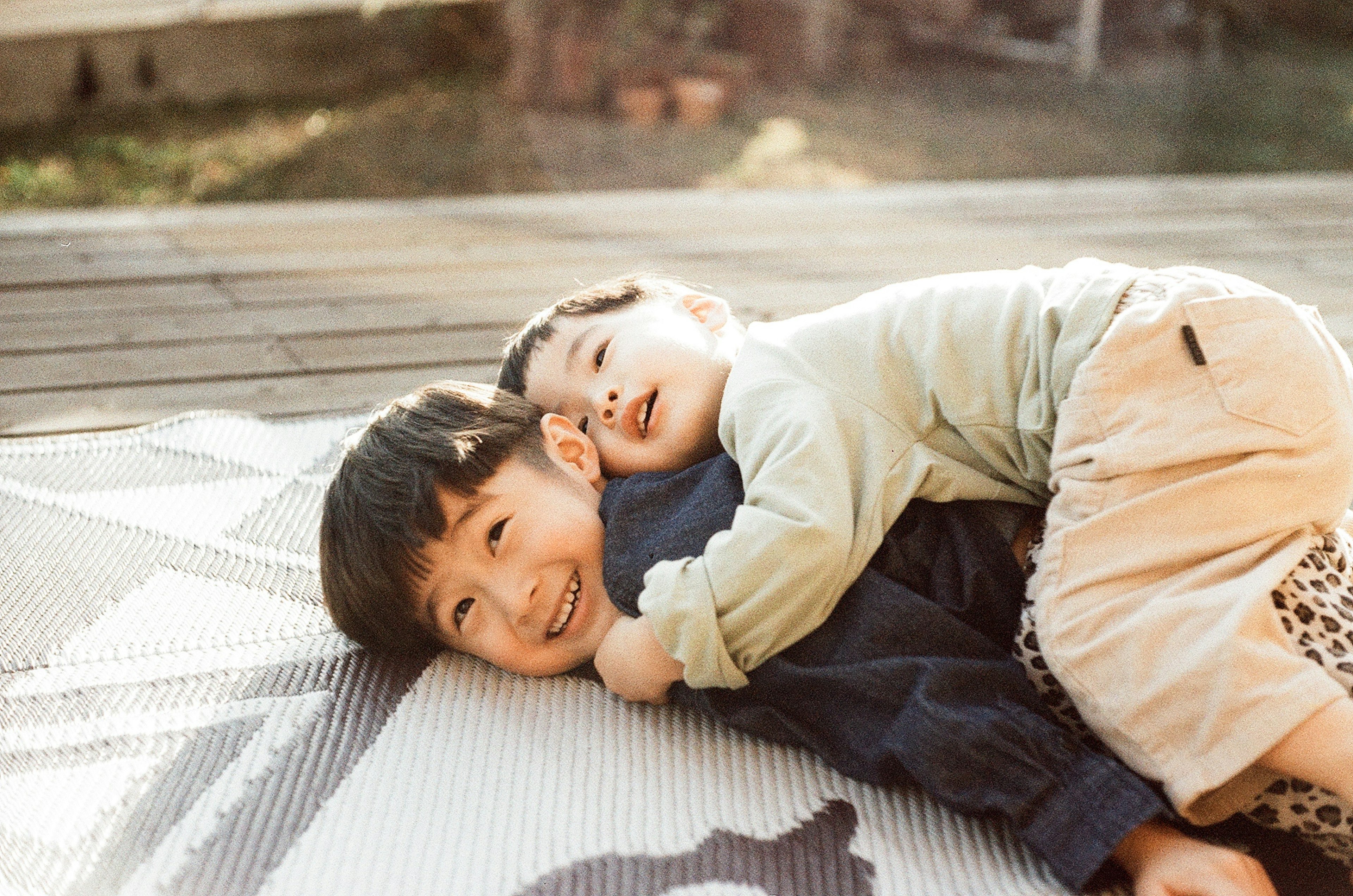 Dos niños jugando en una estera al aire libre