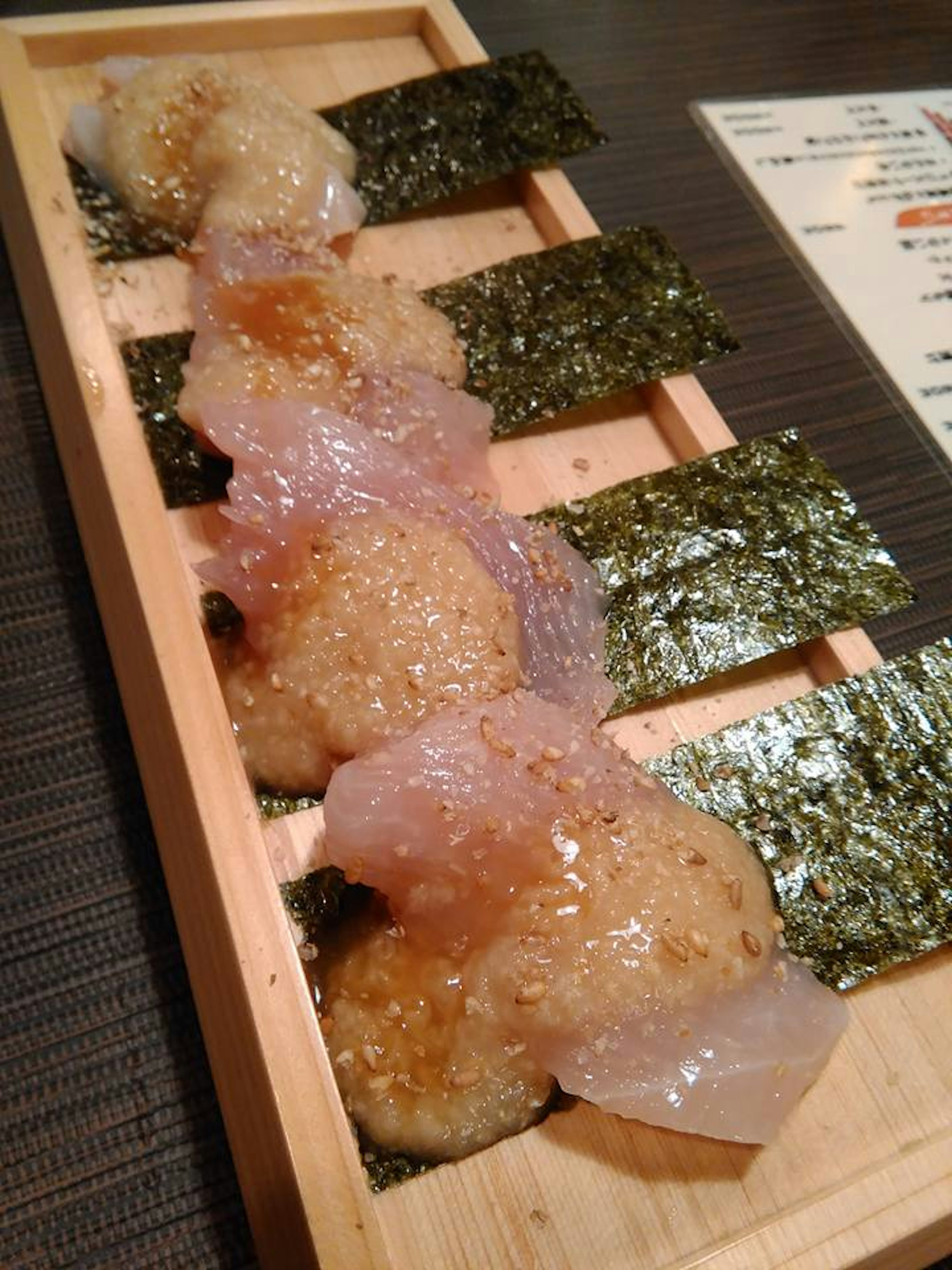 Une assiette en bois avec des sushis et des rouleaux d'algues disposés soigneusement