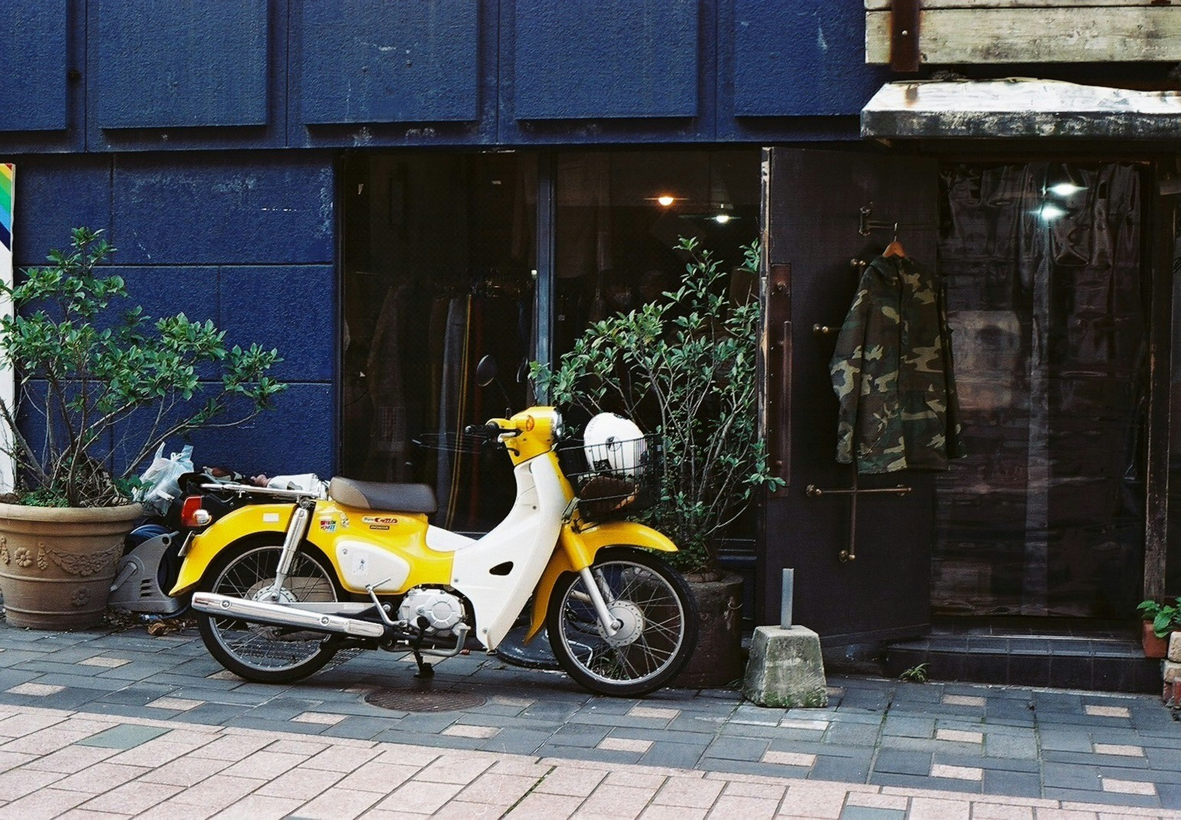 A yellow scooter parked in front of a shop