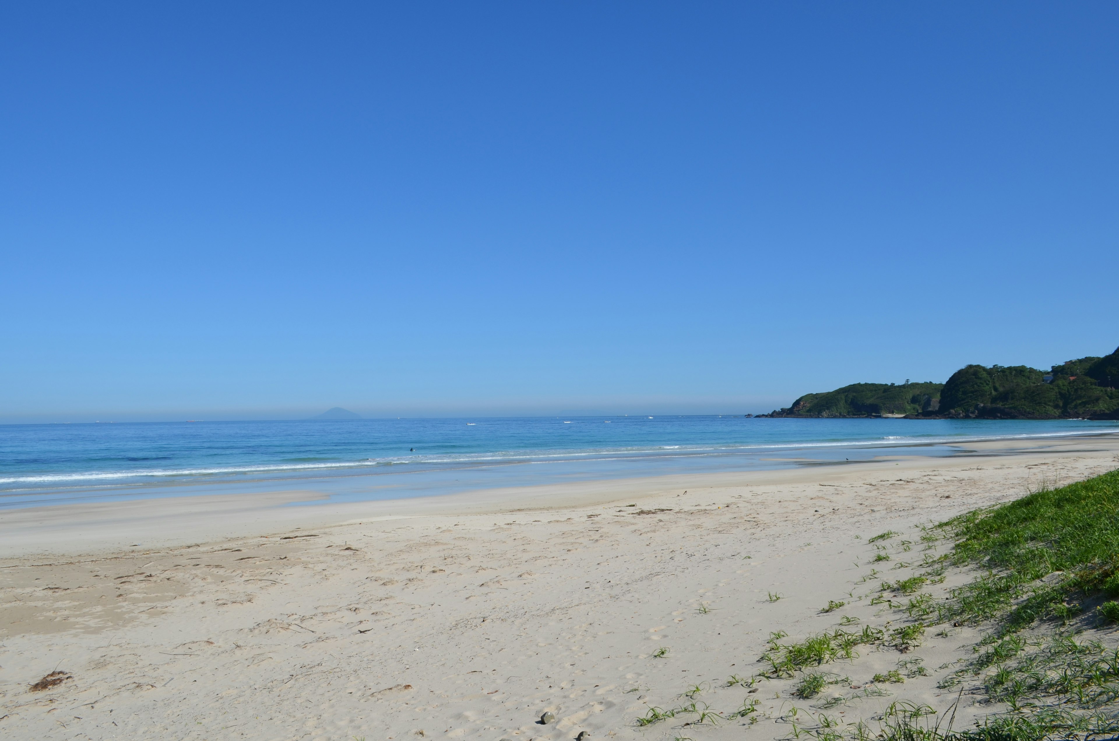 ทิวทัศน์ชายหาดที่มีท้องฟ้าสีฟ้าและทะเลสงบ