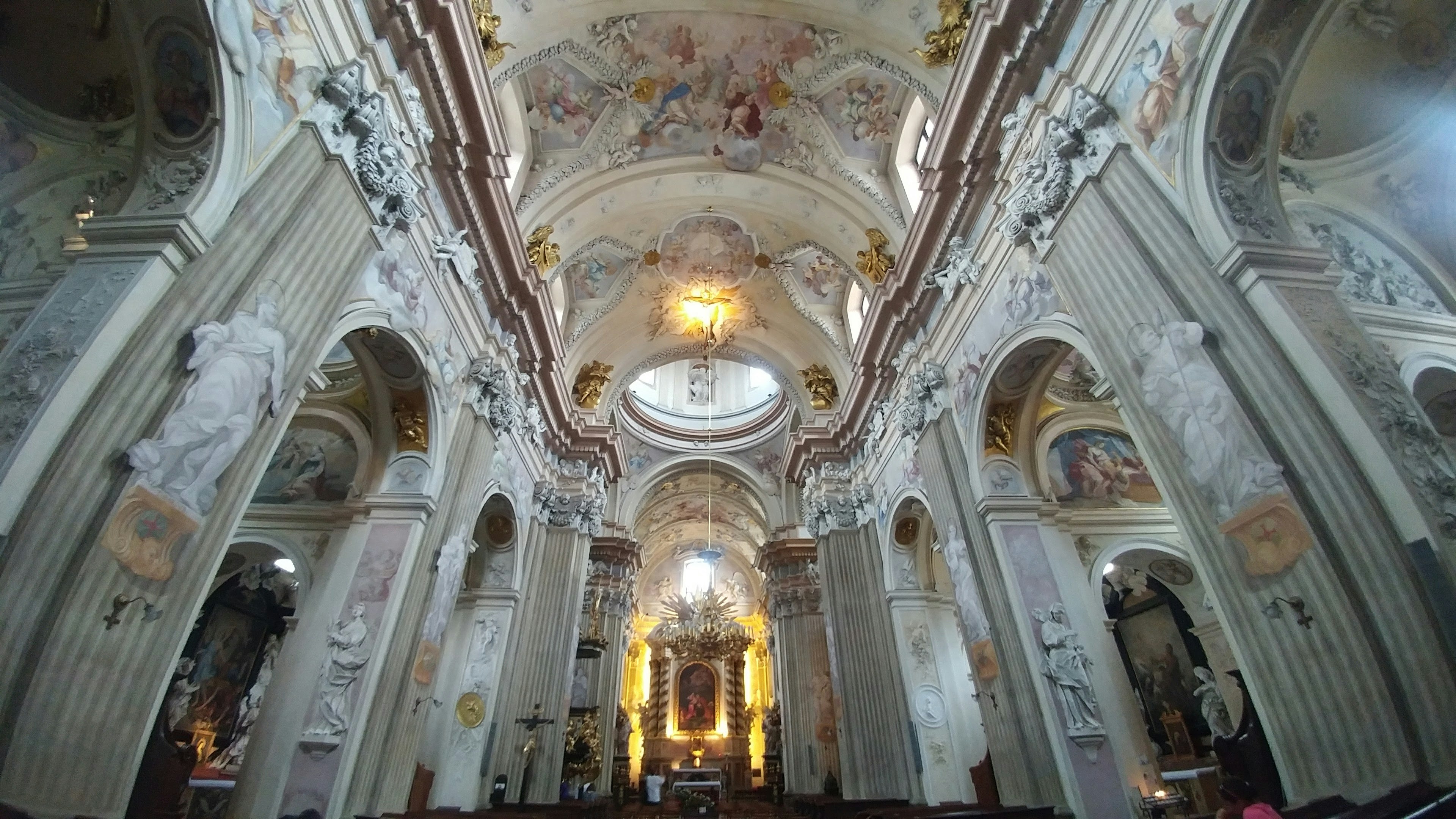 Interior gereja yang megah dengan langit-langit berornamen dan kolom cahaya lembut masuk