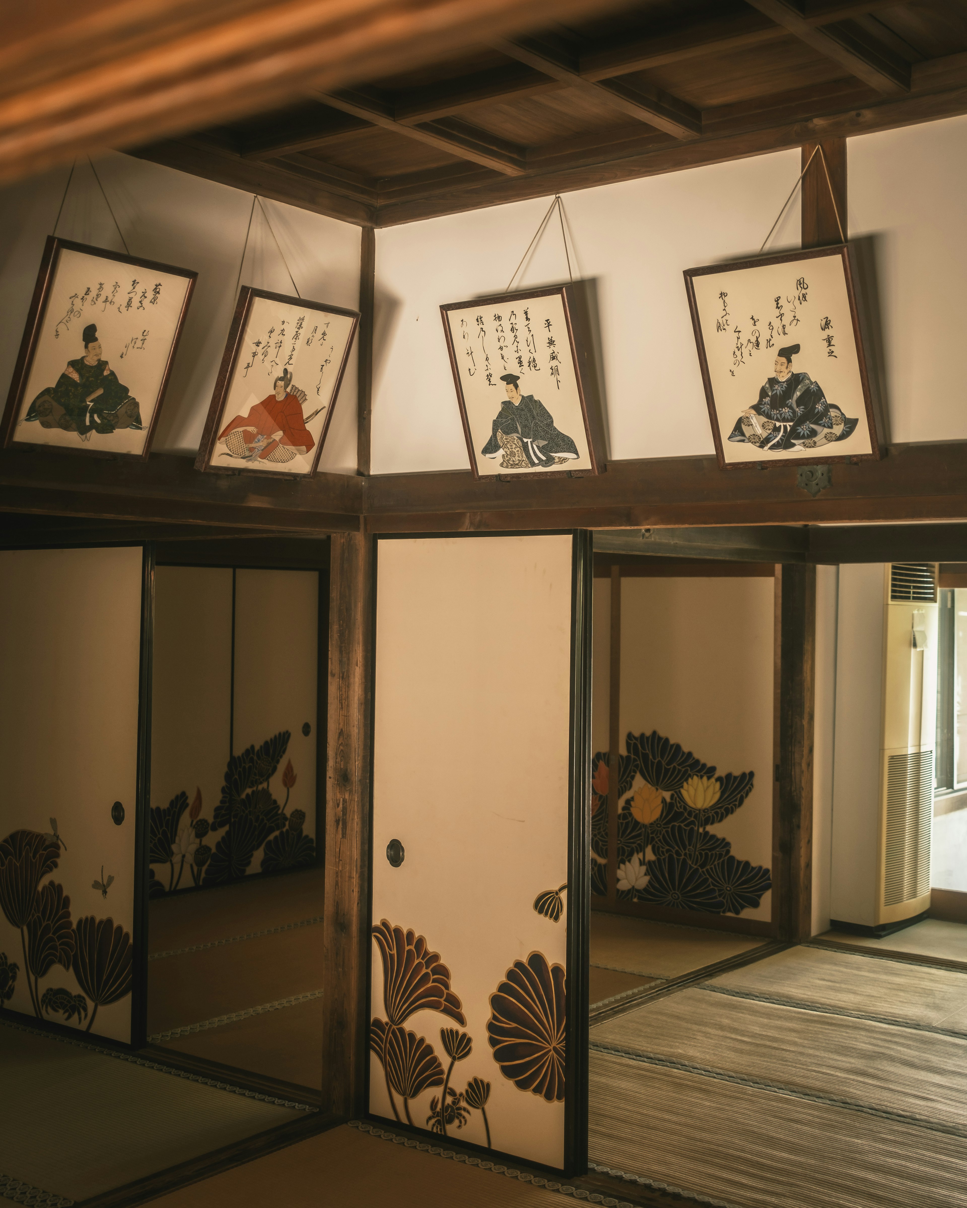 Interior of a traditional Japanese room featuring art on the walls sliding doors and tatami flooring