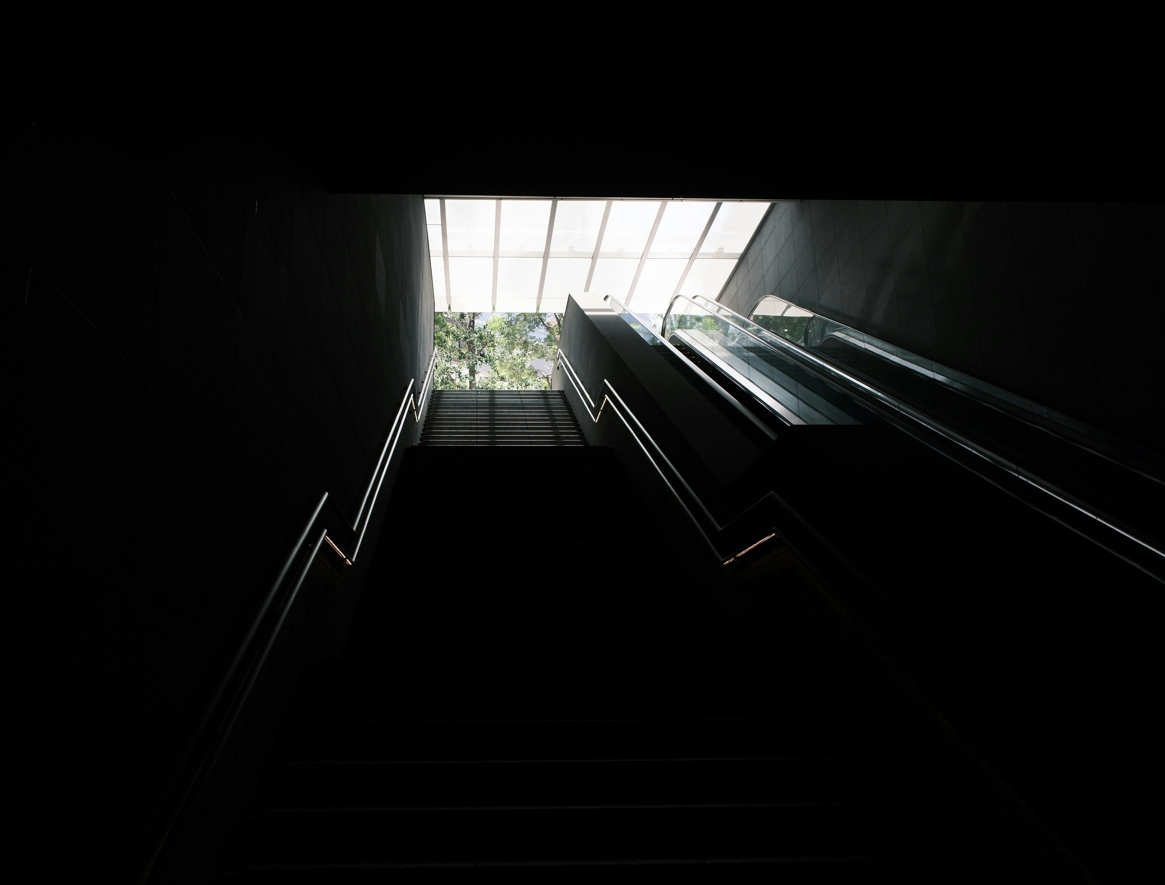 Dark staircase leading to bright skylight above