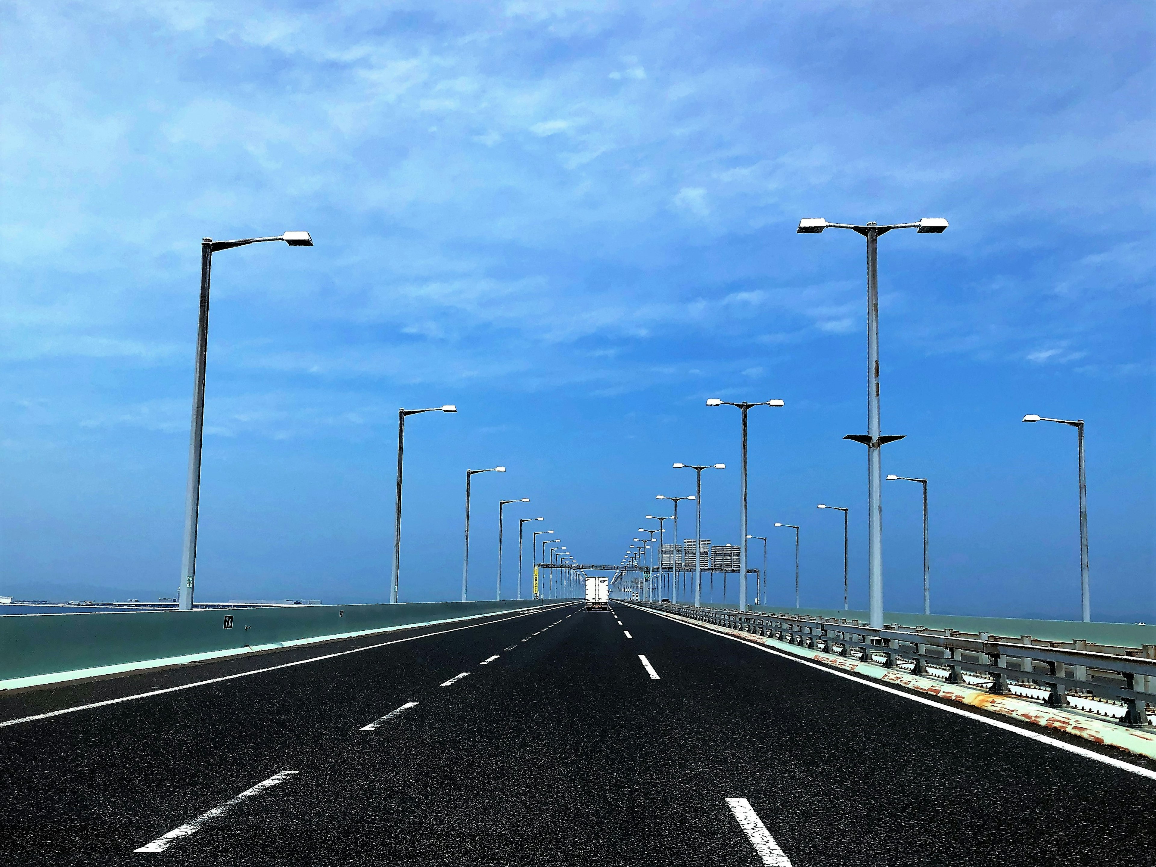 Wide road with streetlights under a blue sky