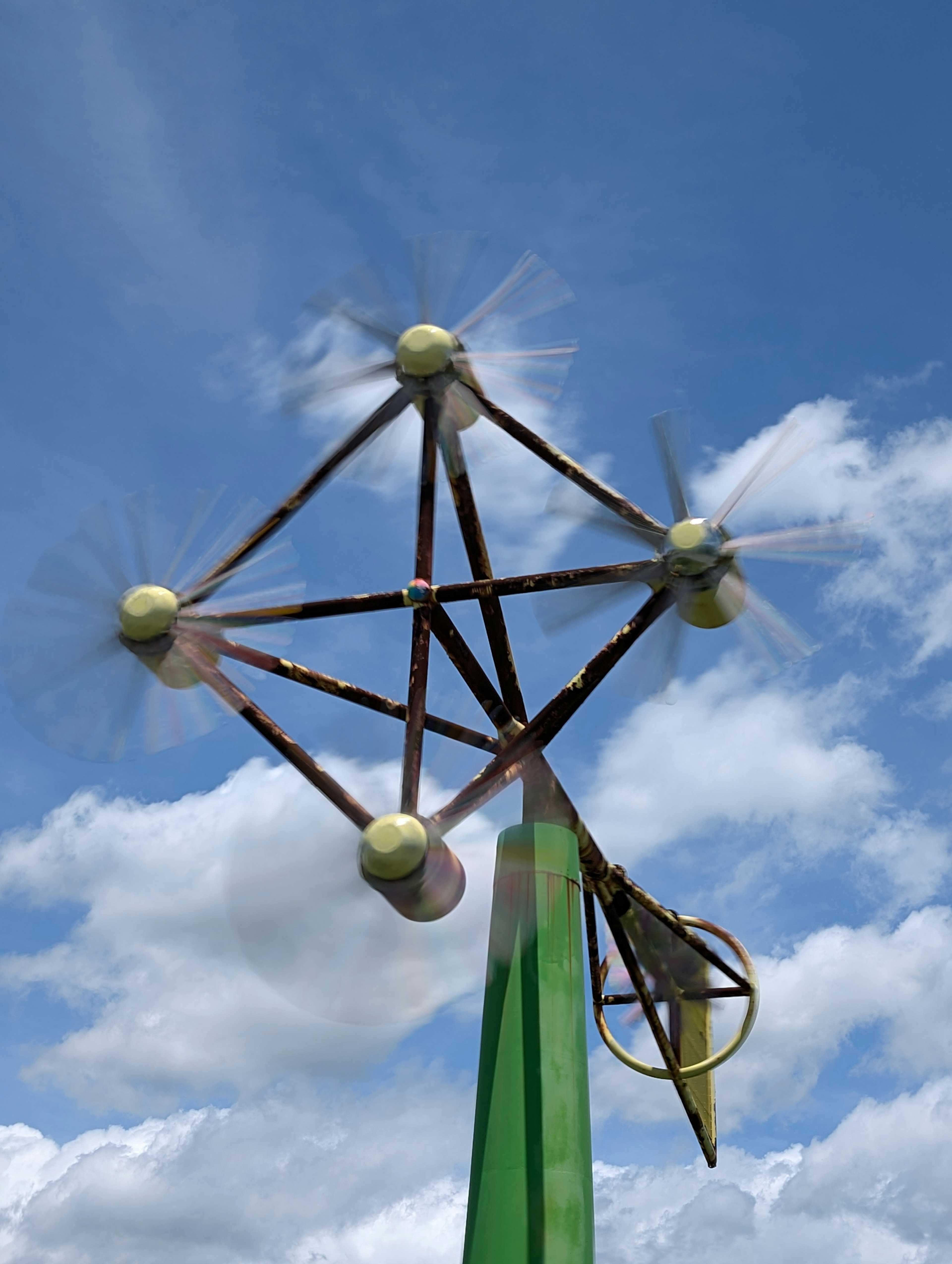 Unique wind turbine design rotating under a blue sky