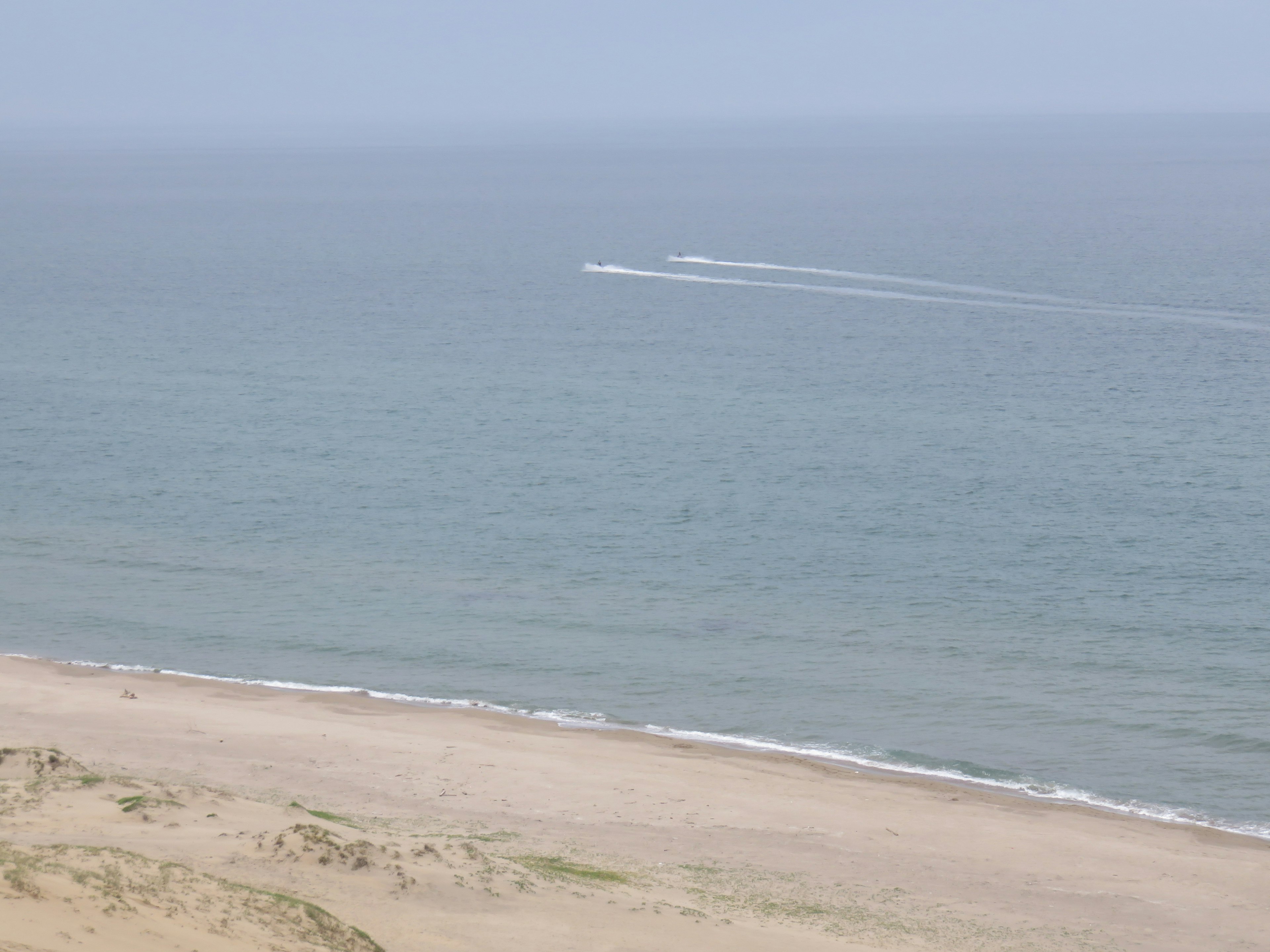 Malersicher Blick auf den Ozean und den Strand mit der Spur eines Boots