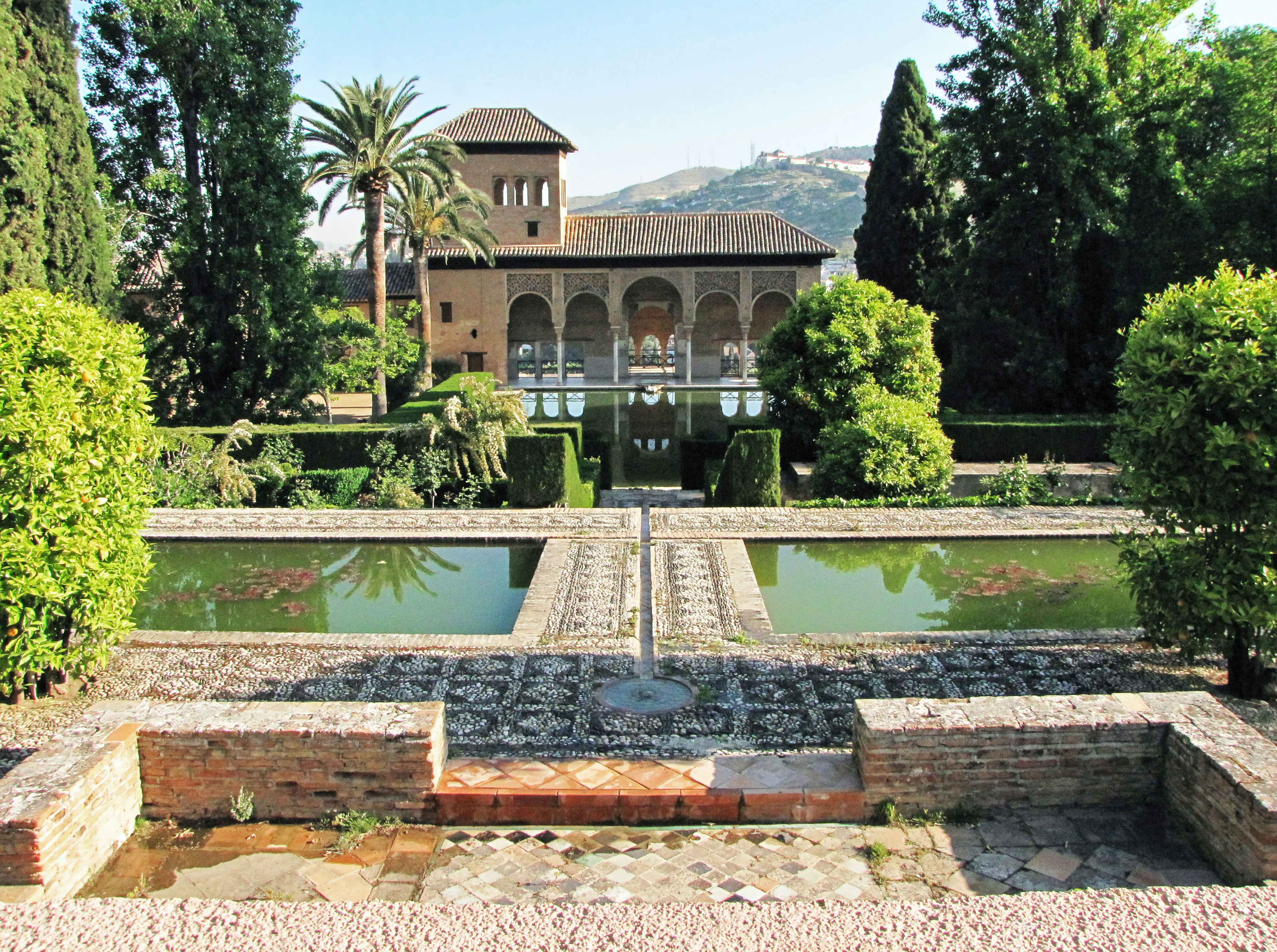 Vista spettacolare dei giardini dell'Alhambra con stagni e vegetazione lussureggiante