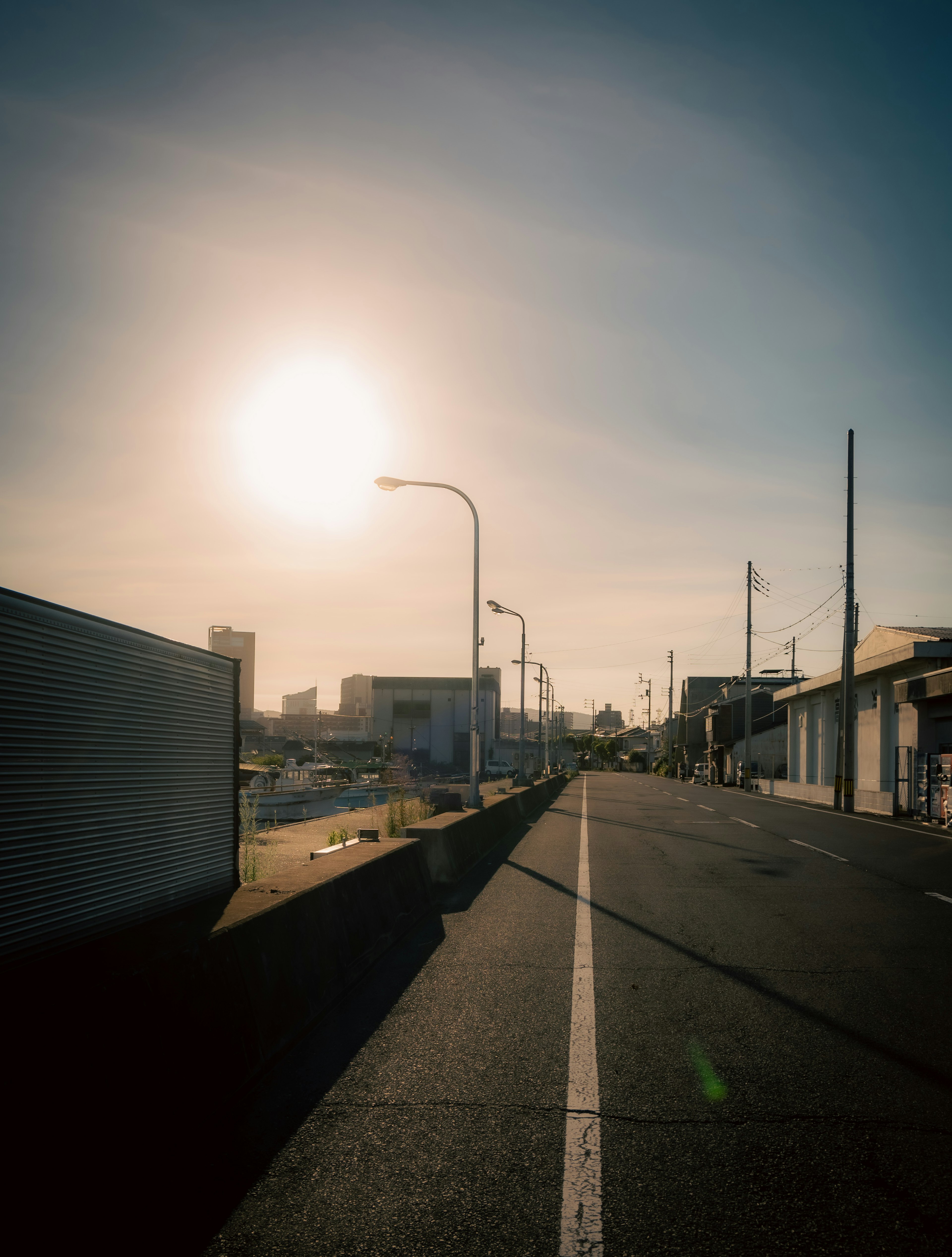 Quiet street with sunset and buildings under blue sky