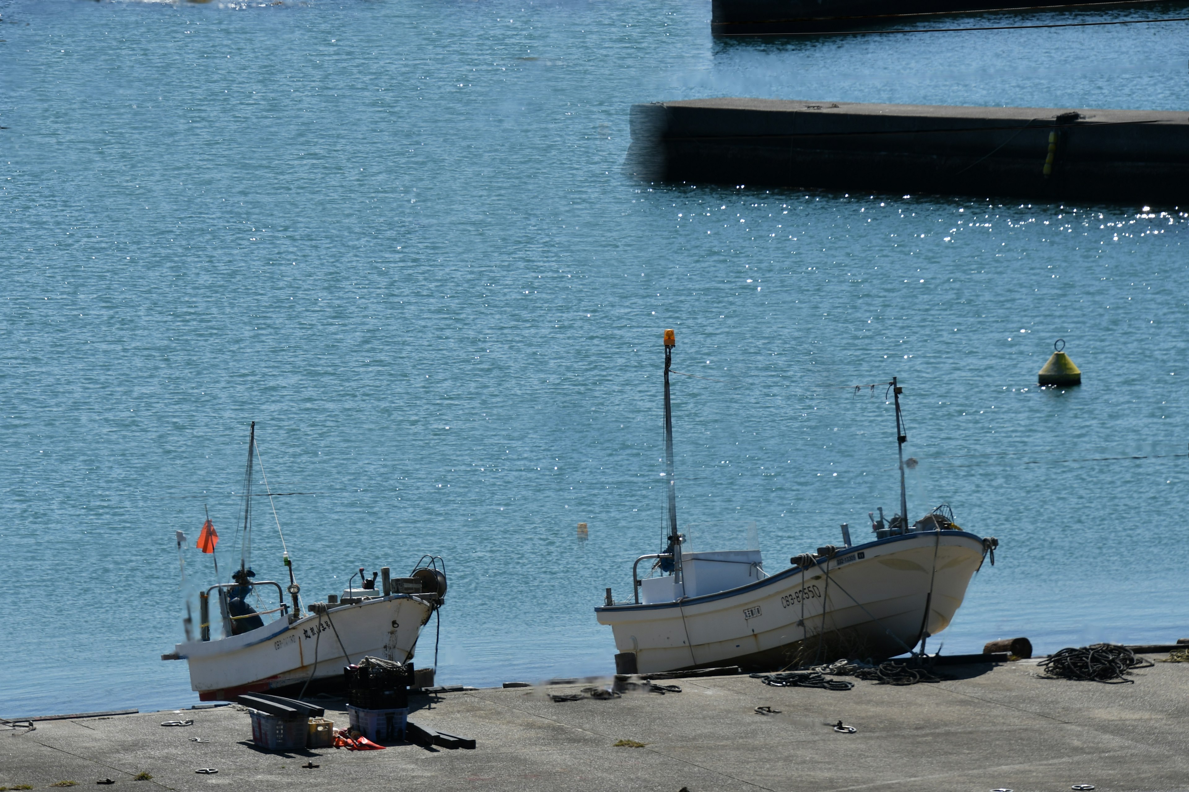 Two small fishing boats on a sandy beach by a blue sea