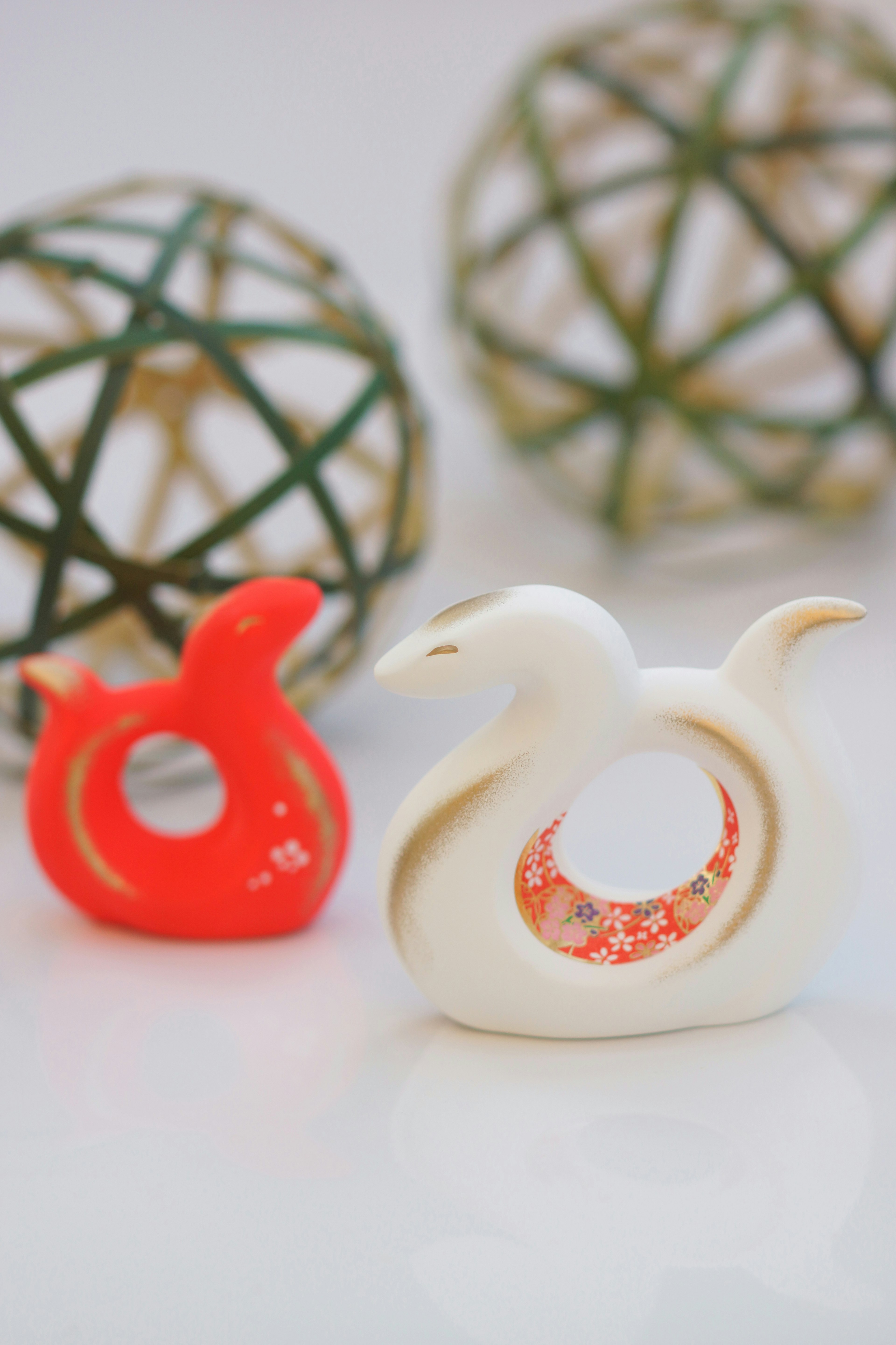 Red and white bird-shaped decorative items with natural sphere backgrounds