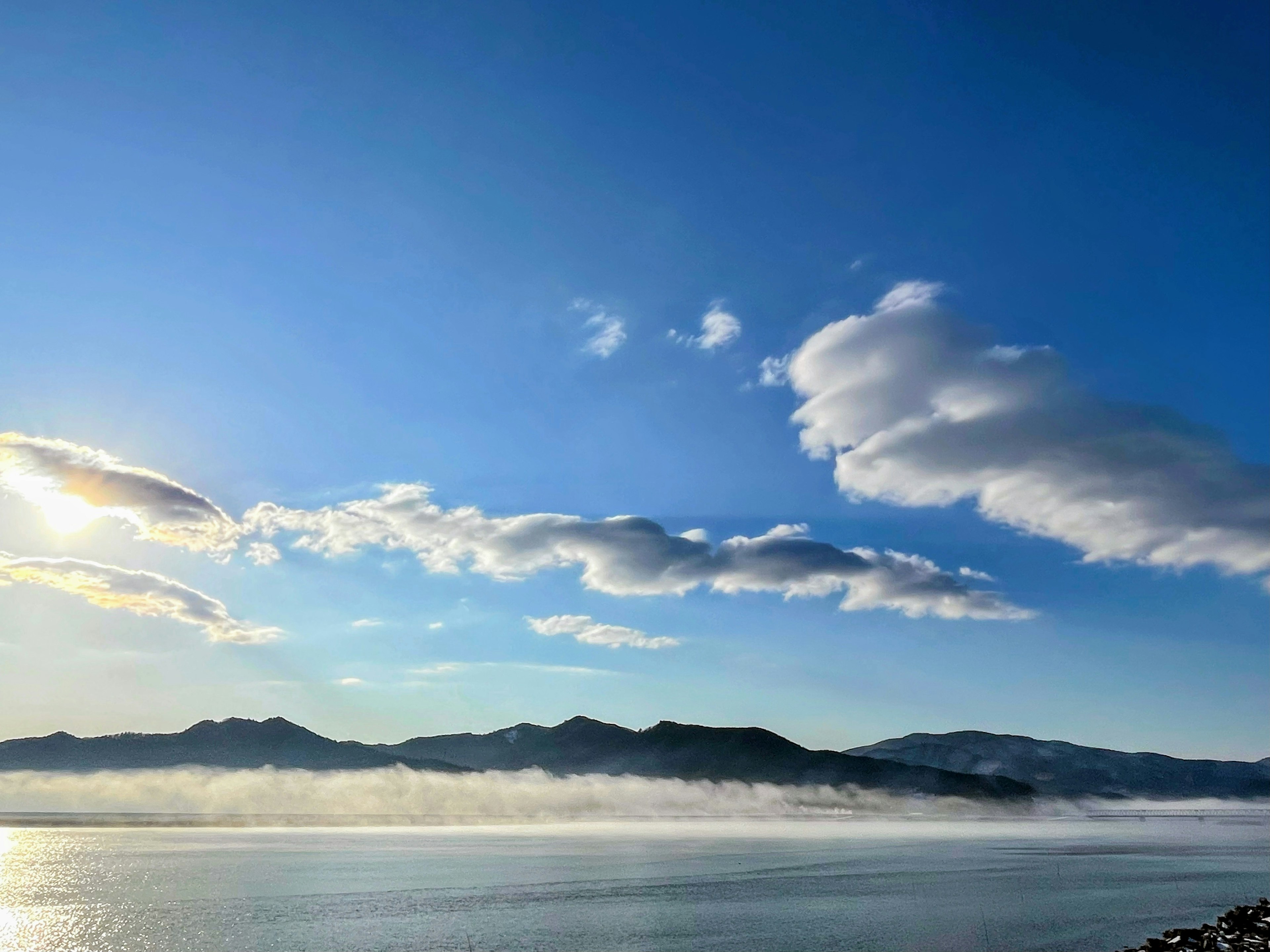 Pemandangan tenang dengan langit biru dan awan putih pegunungan dan air tenang