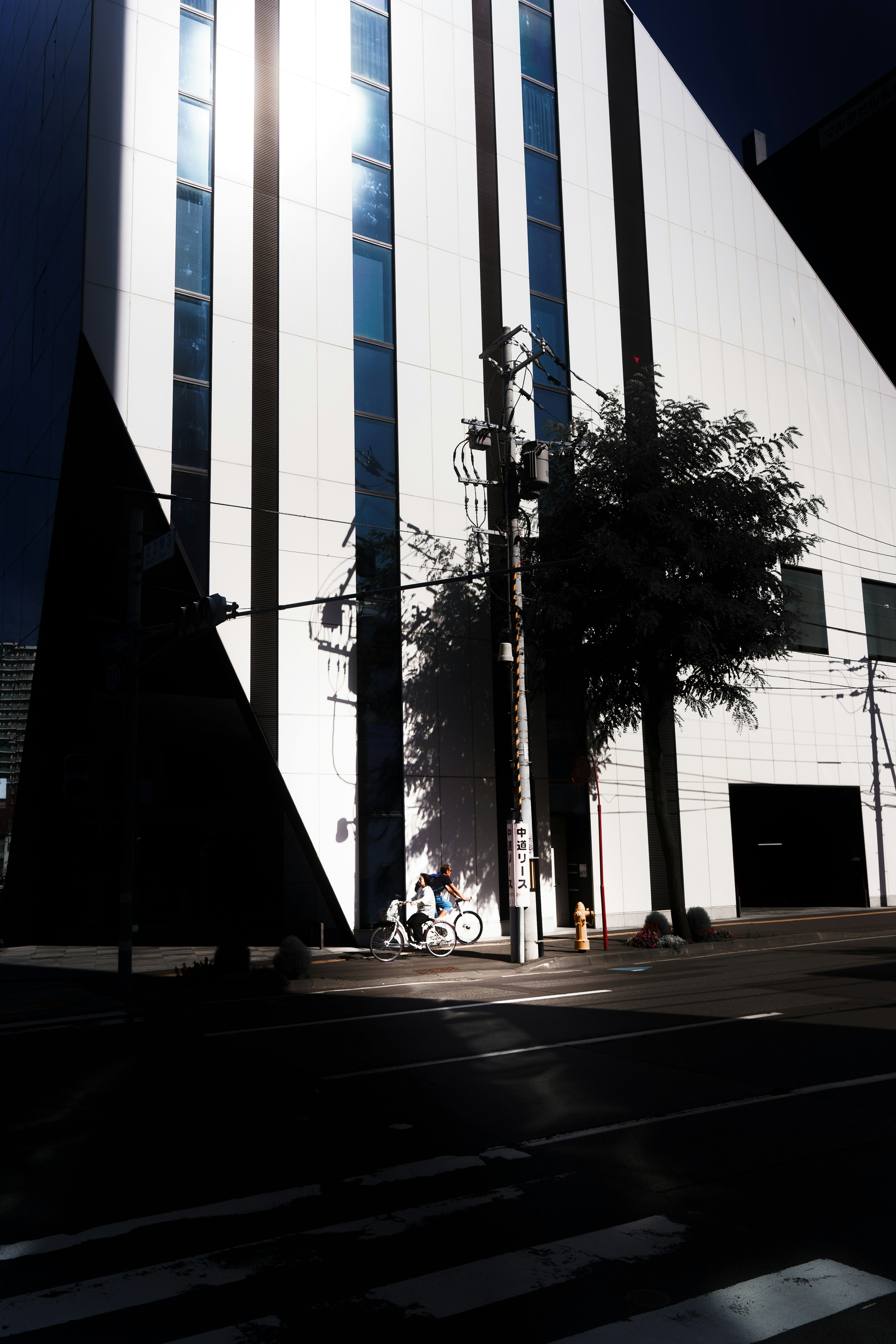 Städtische Szene mit einem weißen Gebäude, das Schatten wirft