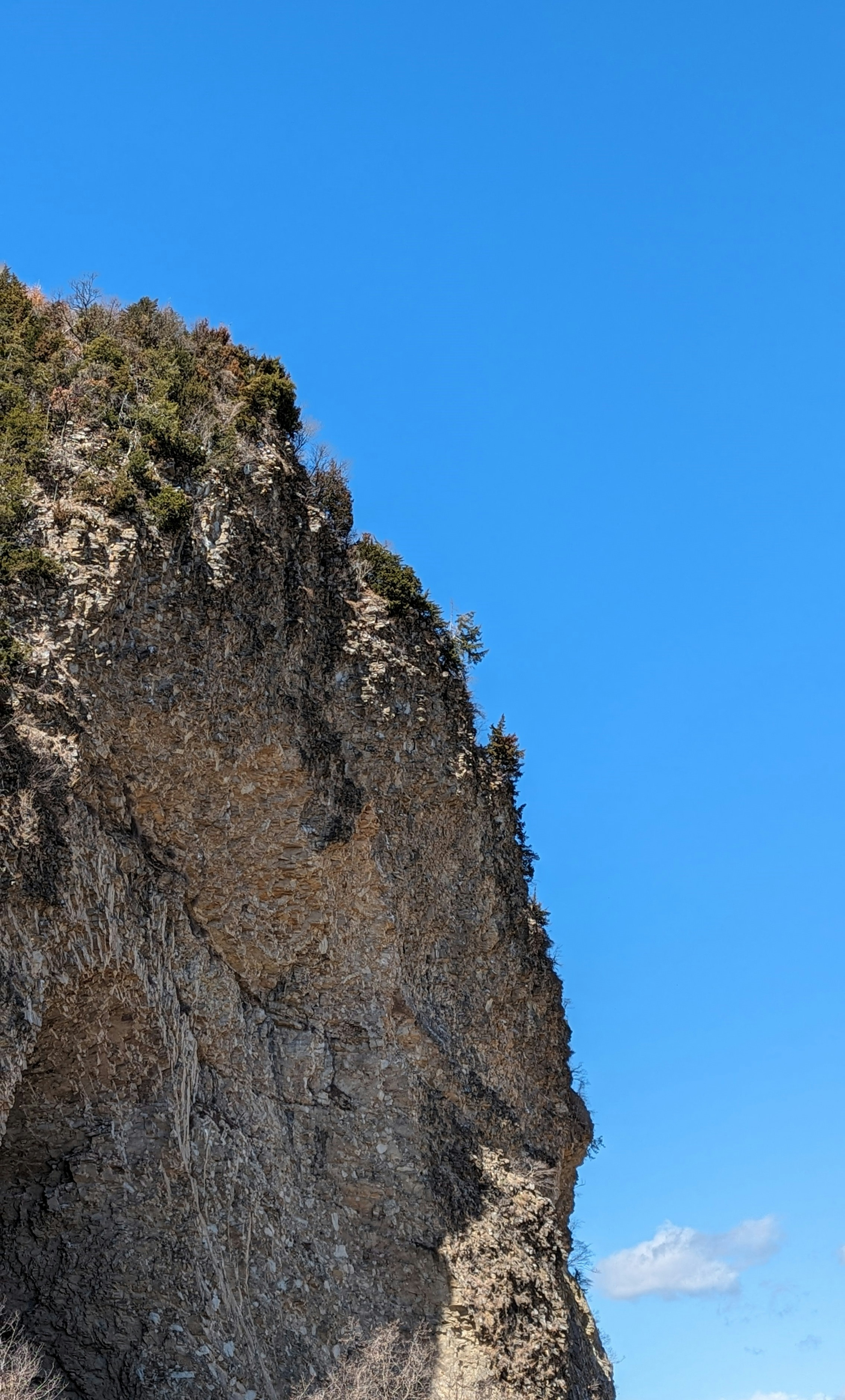 Steep rock cliff against a clear blue sky