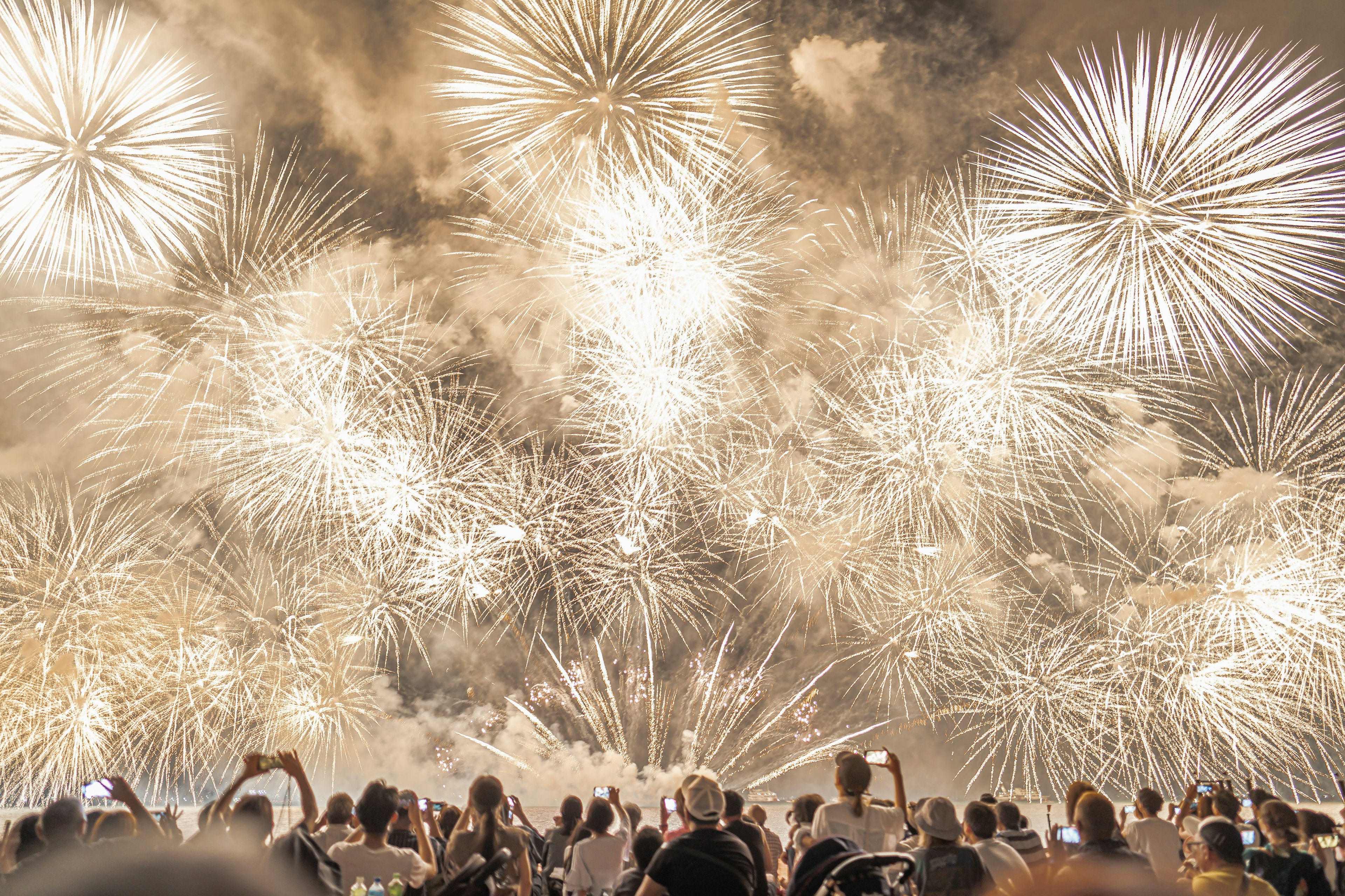 Spektakuläre Show von weißen Feuerwerken mit zuschauenden Menschen