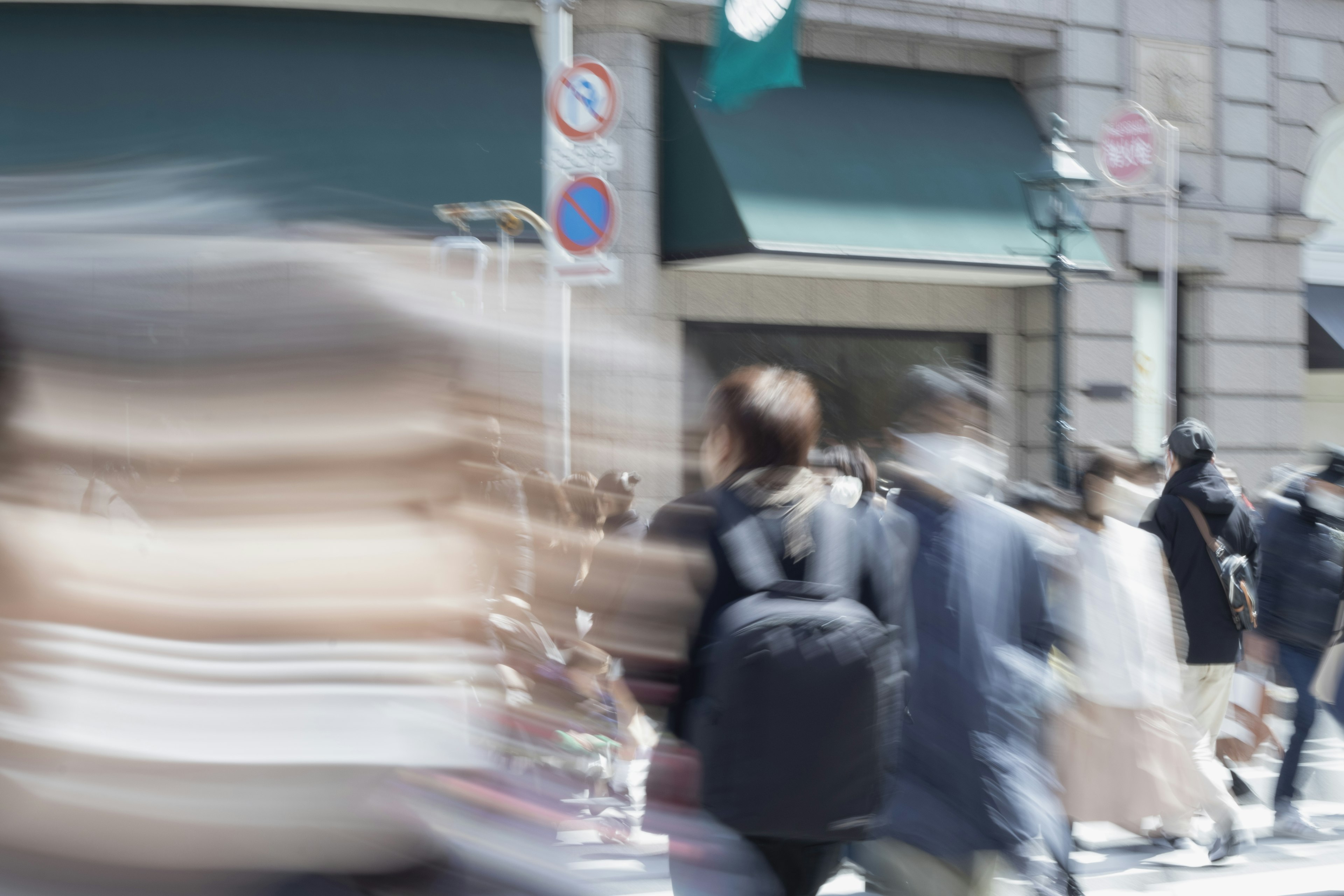 Menschenmenge, die auf einer belebten Straße mit verschwommenem Hintergrund geht