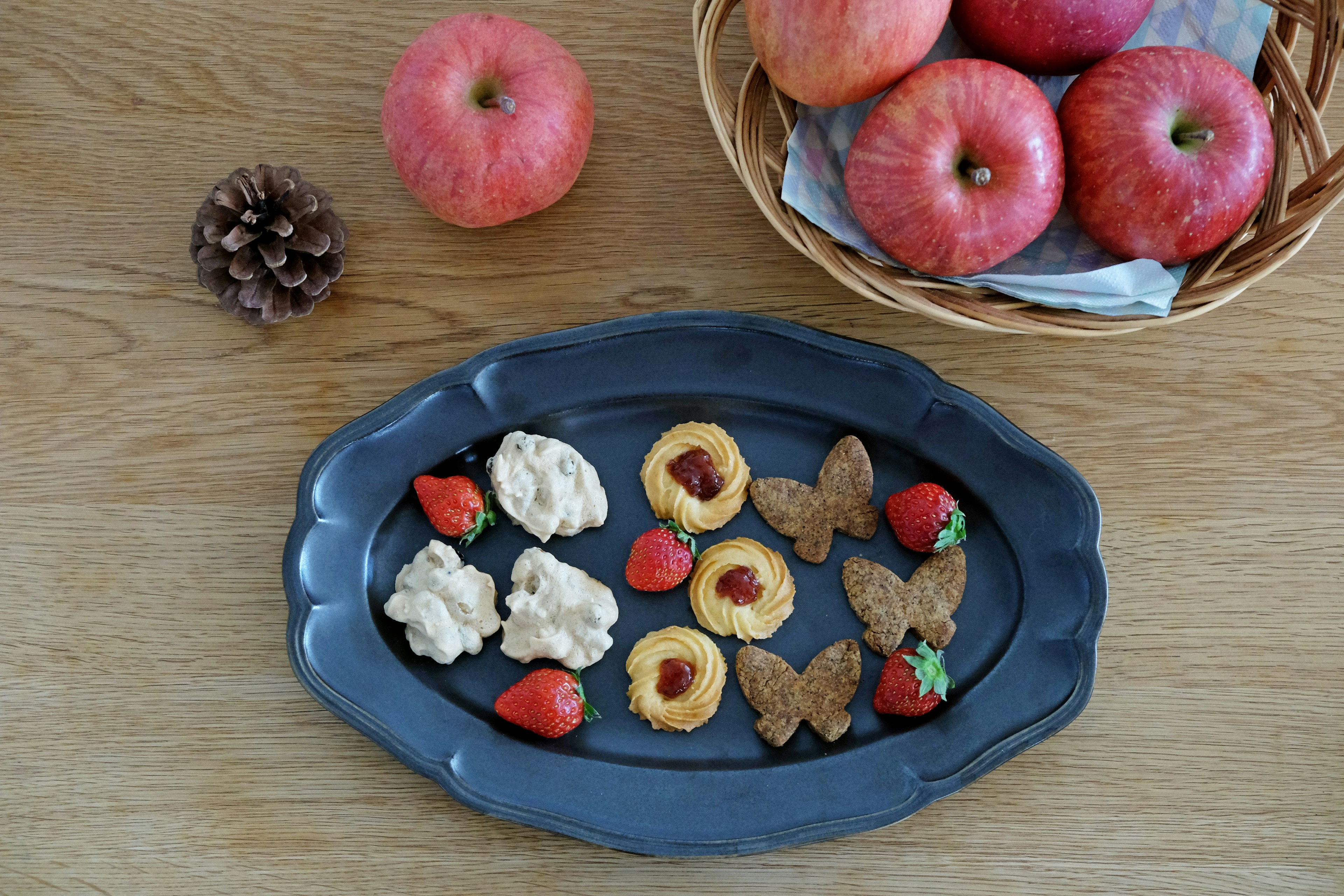 Une table avec des pommes rouges et un assortiment de pâtisseries