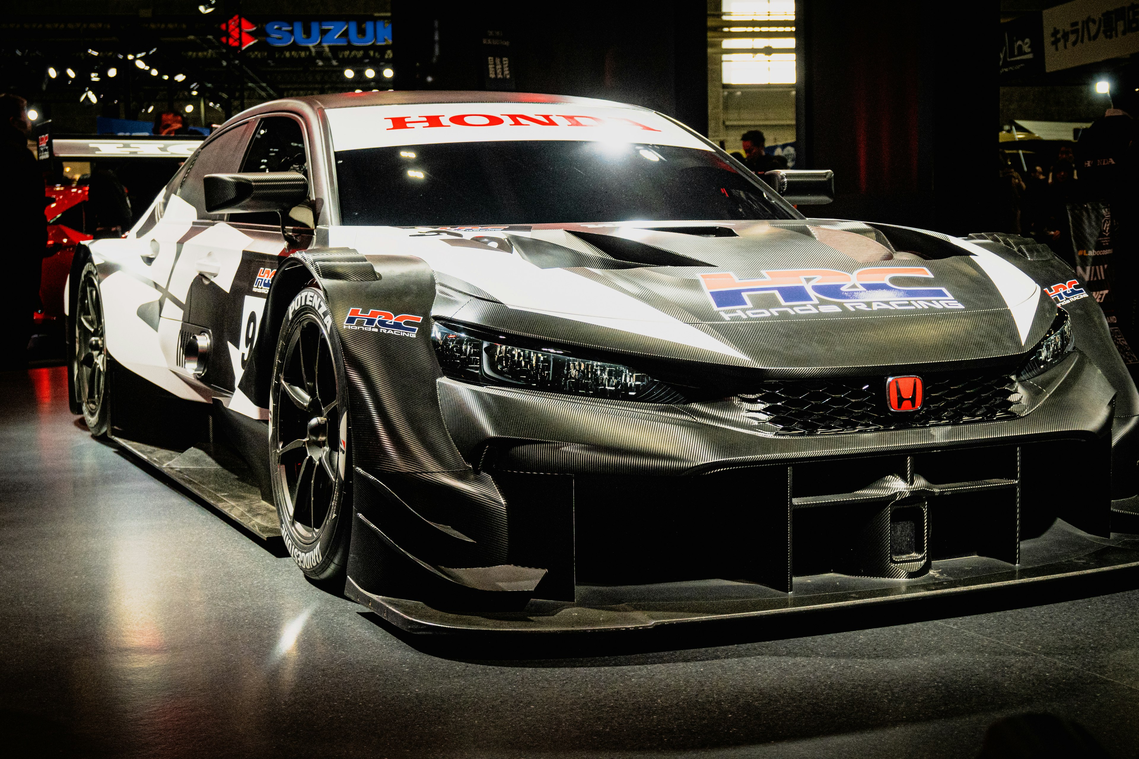 A sleek black racing car on display in a modern showroom