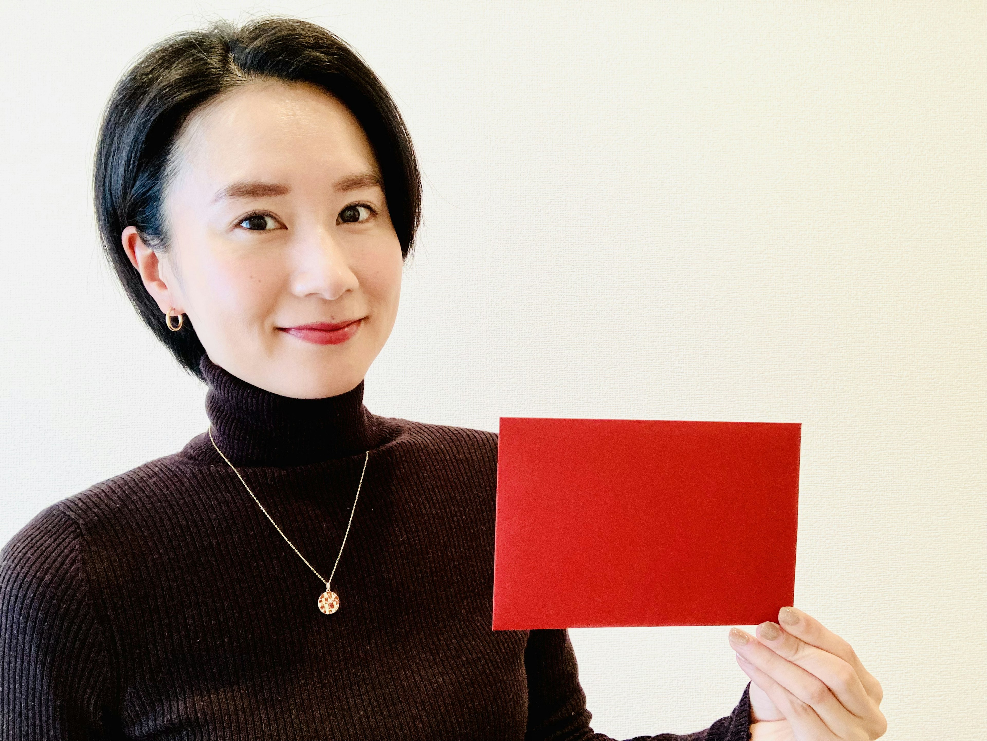 Woman smiling while holding a red envelope