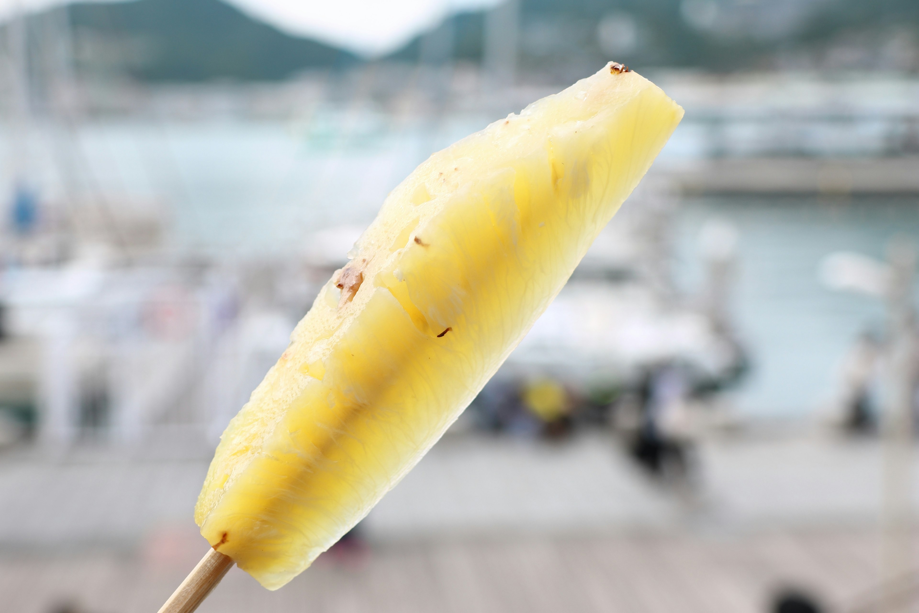 Banana grigliata su uno stecco con sfondo di marina